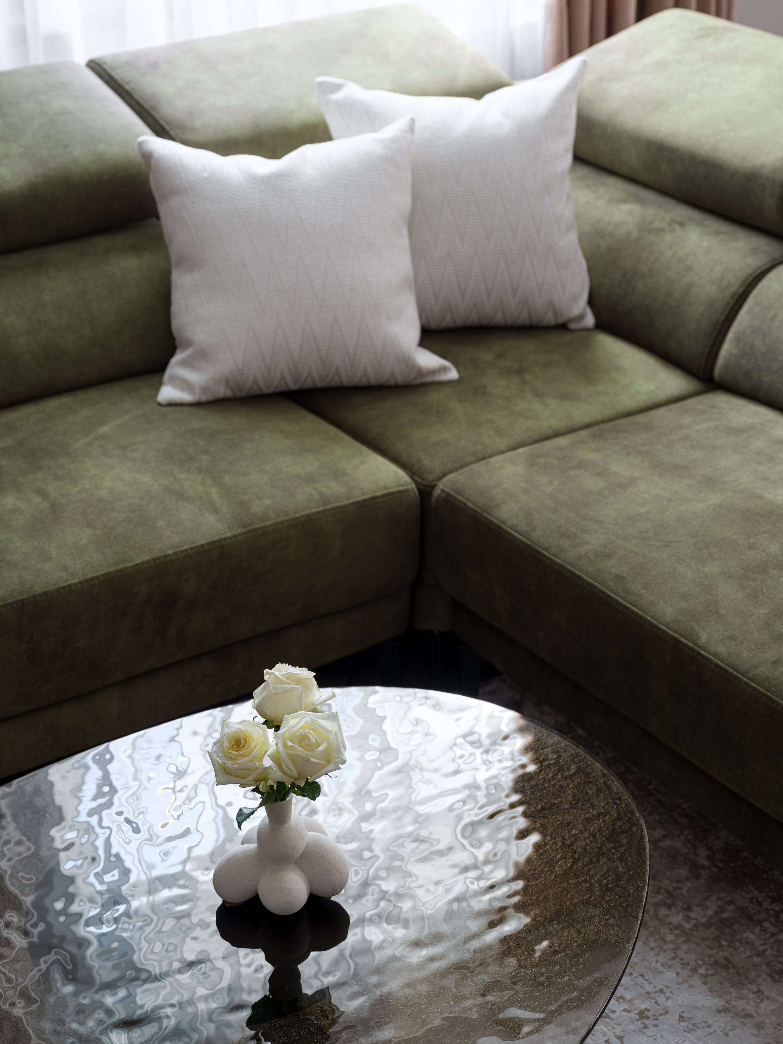 Современный стиль интерьера с акцентом на уют: фото фрагмента гостиной с зелёным диваном, подушками и вазой с белыми розами. Автор интерьера Татьяна Диденко, фото Сергей Денисенко, стилизация Наталья Якушева.