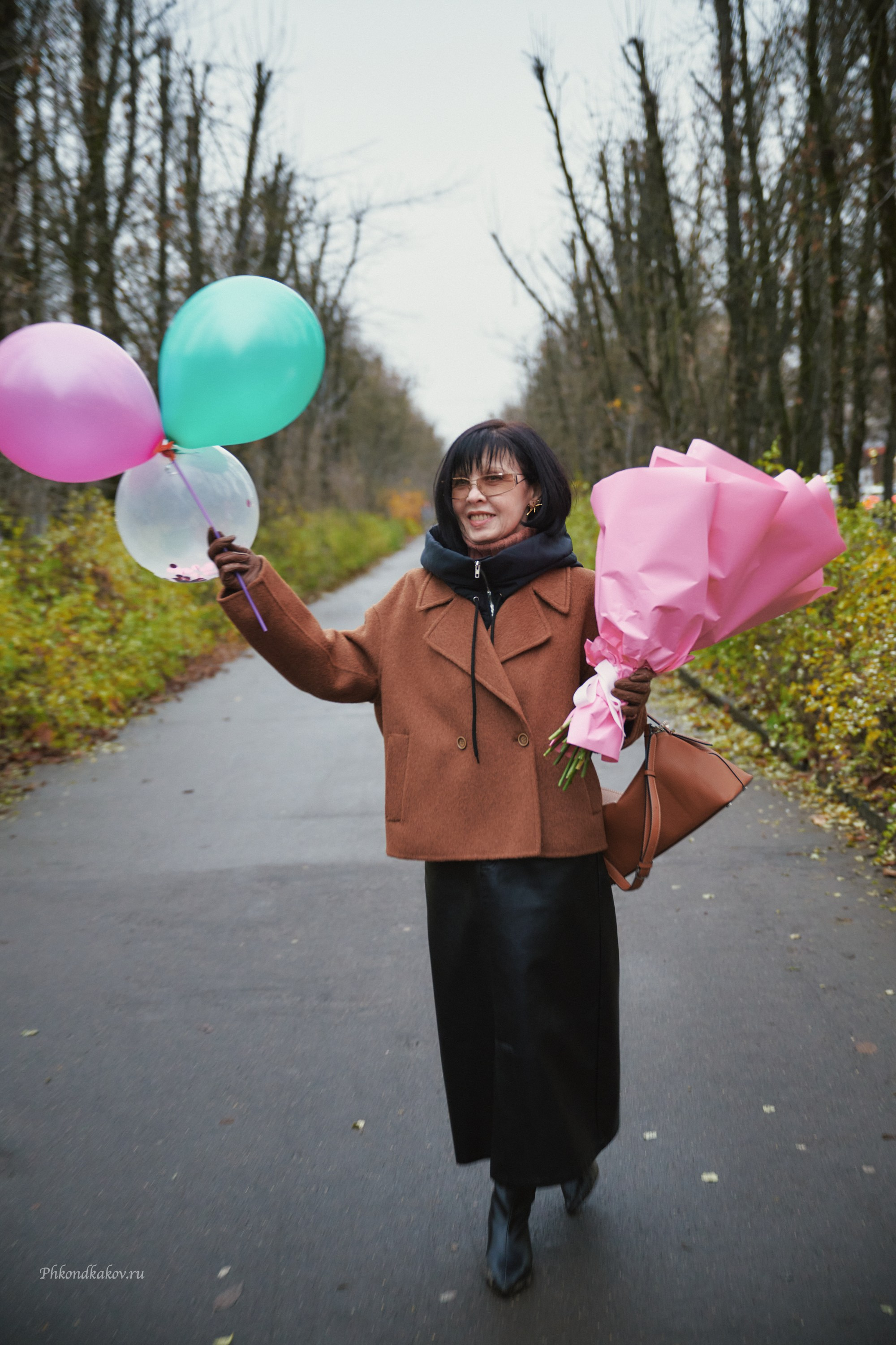 Женщина в осеннем парке с шариками и букетом цветов