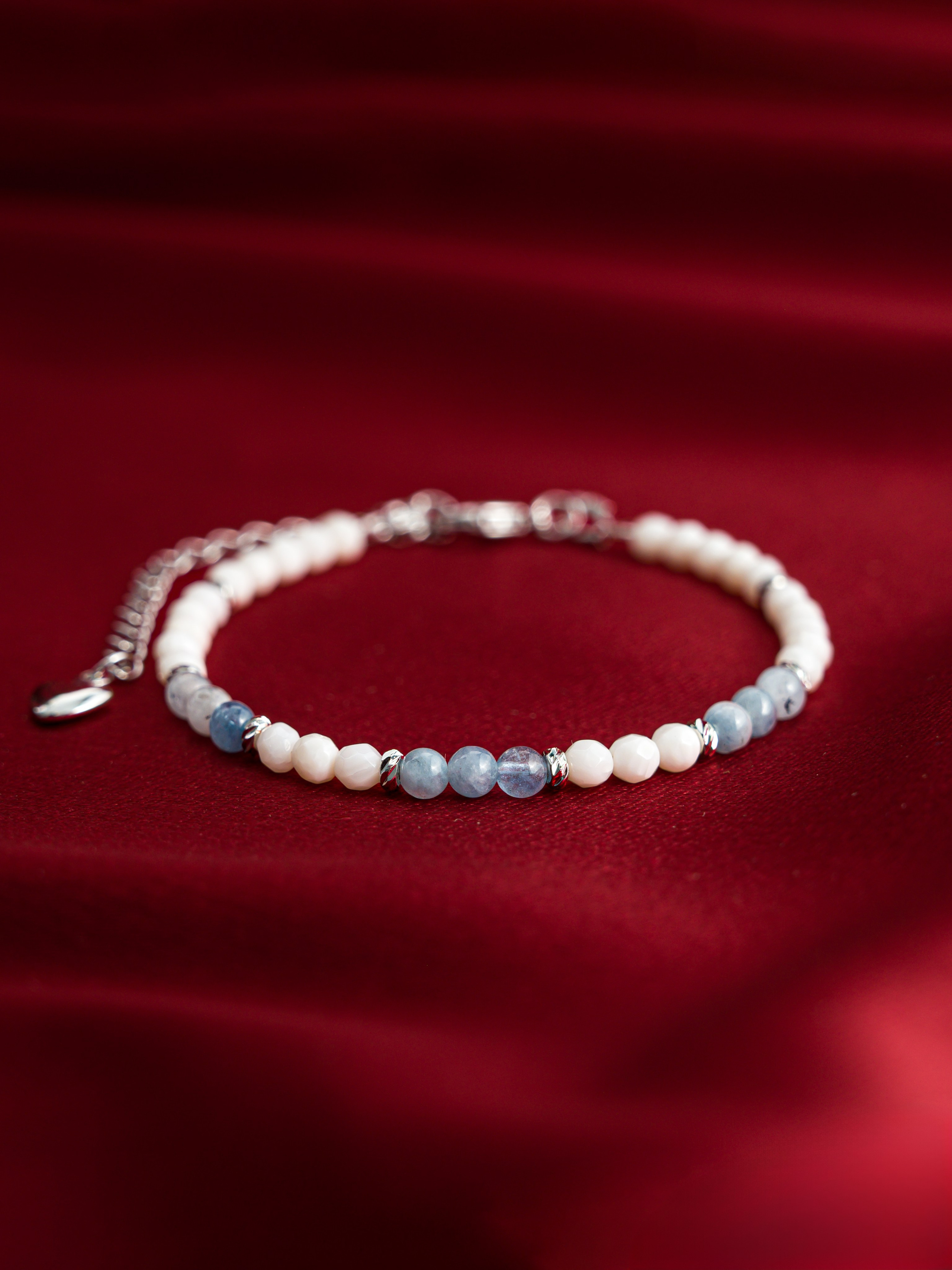 Браслет из натуральных камней на красном фоне — предметная съемка для карточки товара Ozon, фото Алексей Клейменов