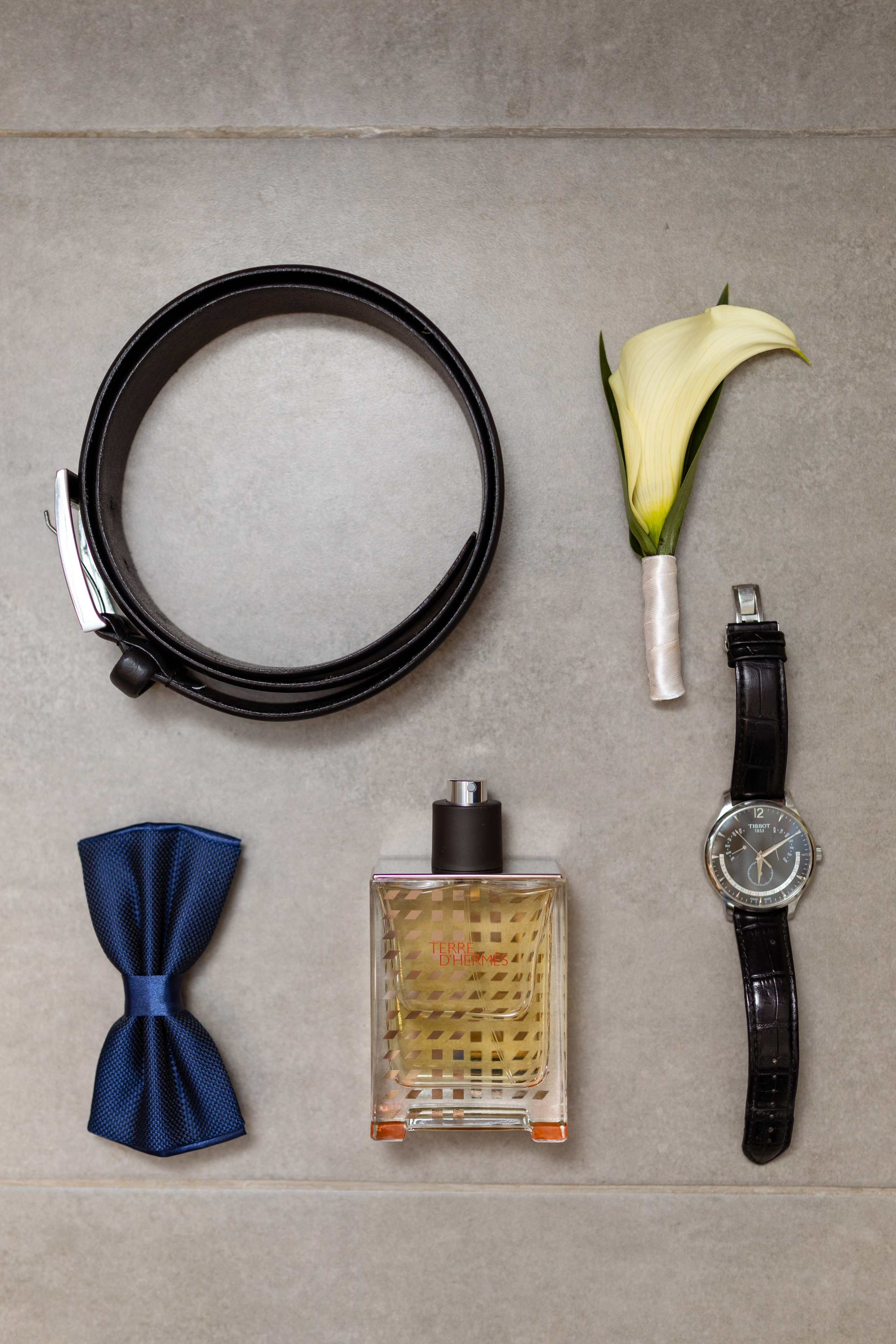 На фото ремень, одеколон, часы, бабочка.