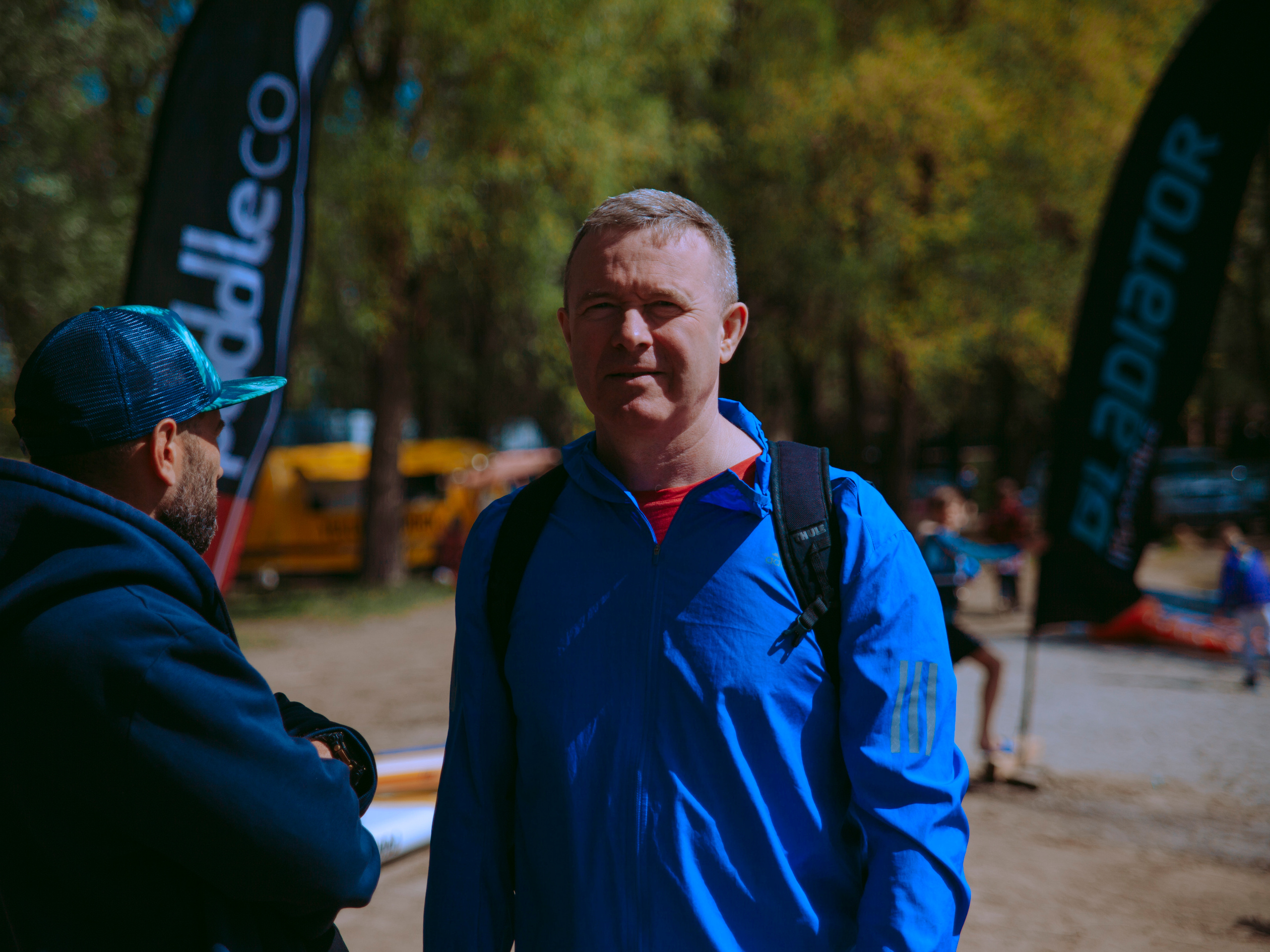 Мужчина в возрасте улыбается в камеру.