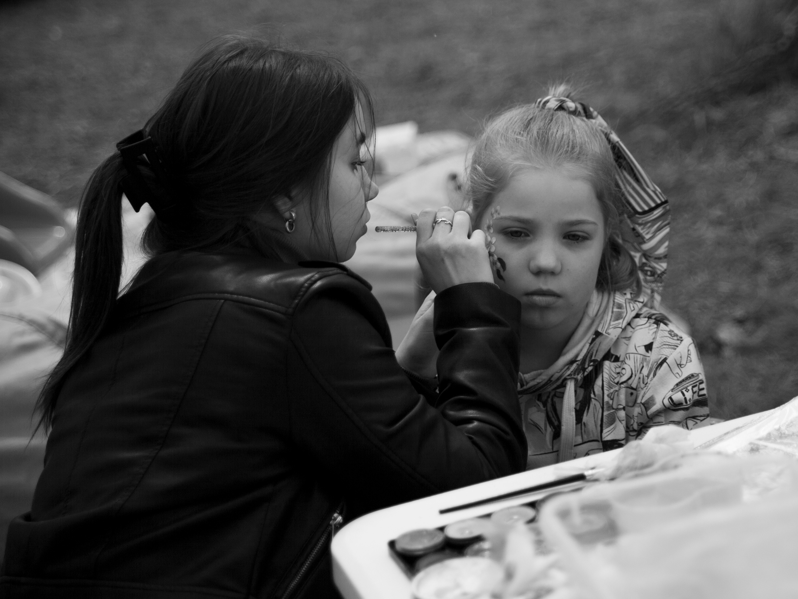 Девочке рисуют на лице.