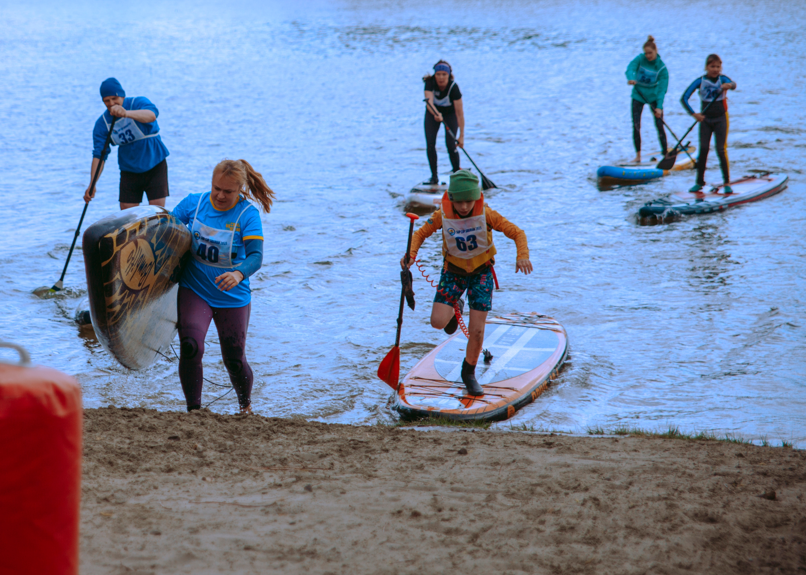 Люди выходят из воды с сапами.
