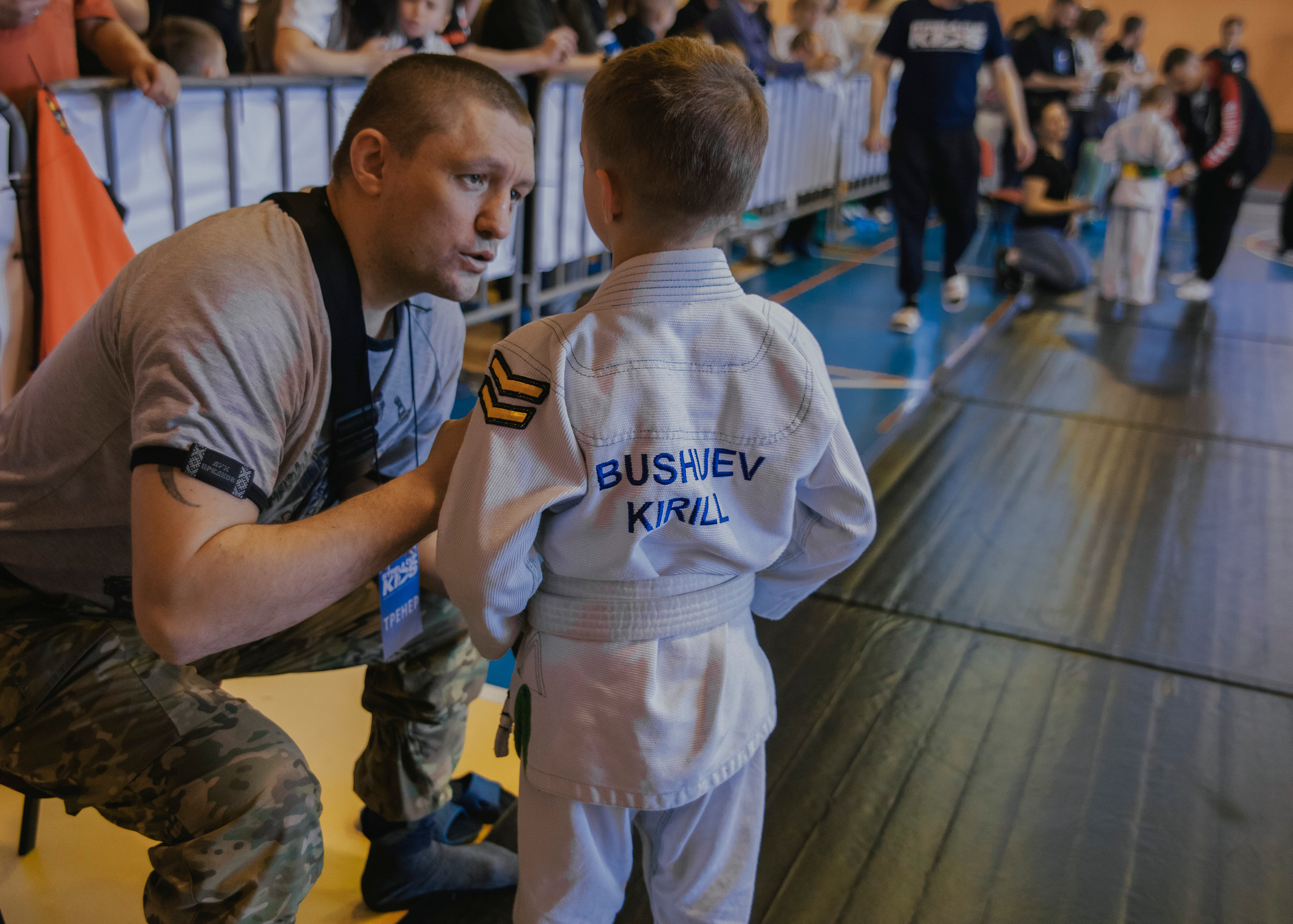 Тренер дает наставления на детском турнире по джиу-джитсу.