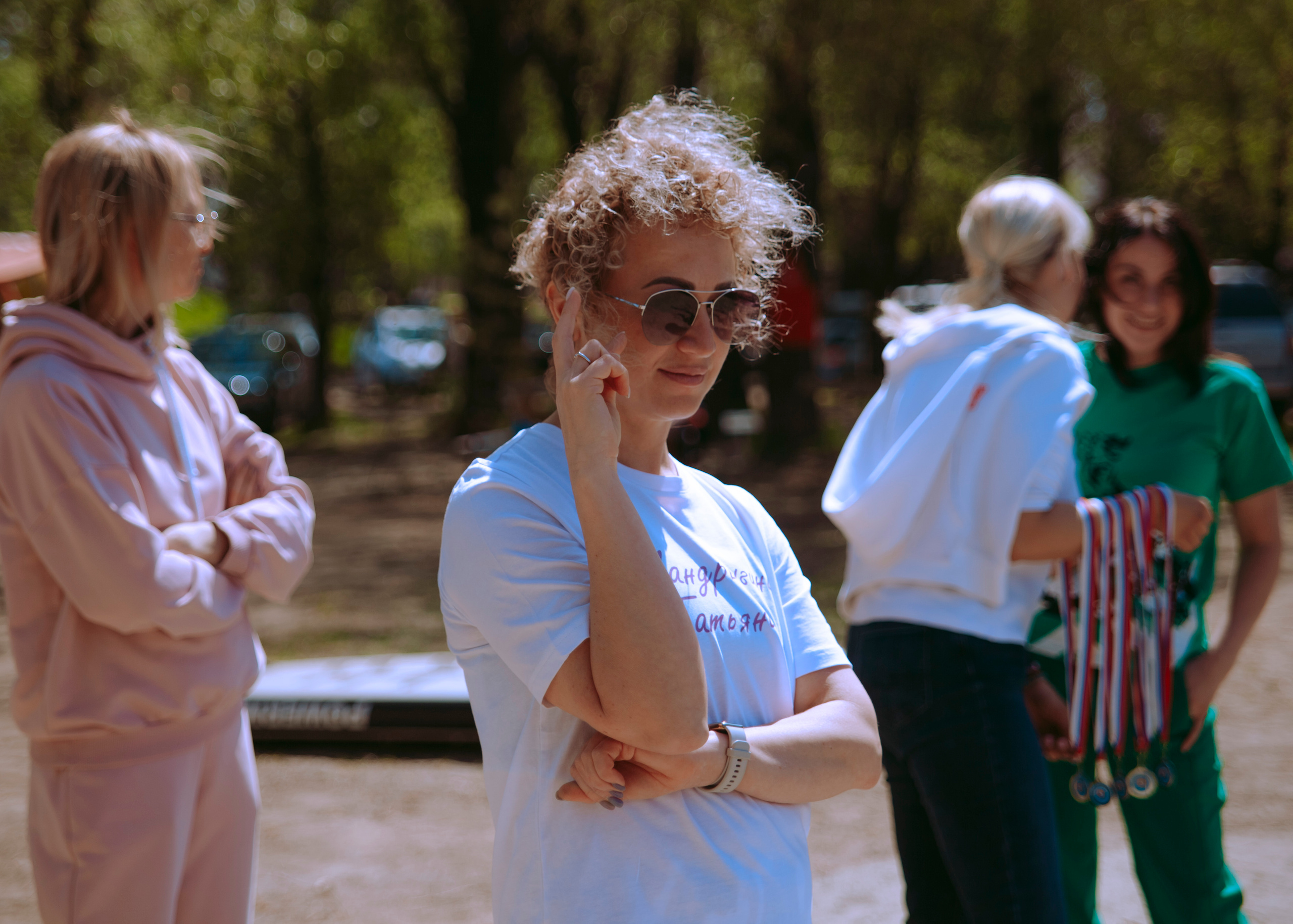 Кудрявая женщина поправляет очки.