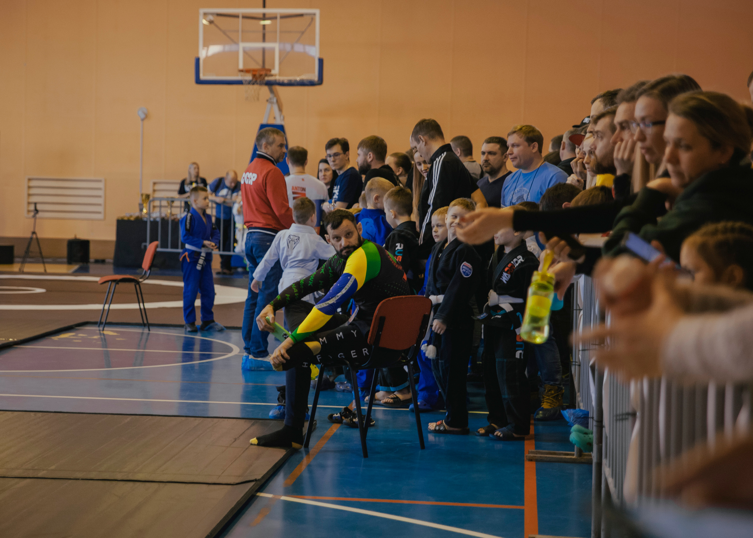 Задумчивый тренер на детском турнире по джиу-джитсу.