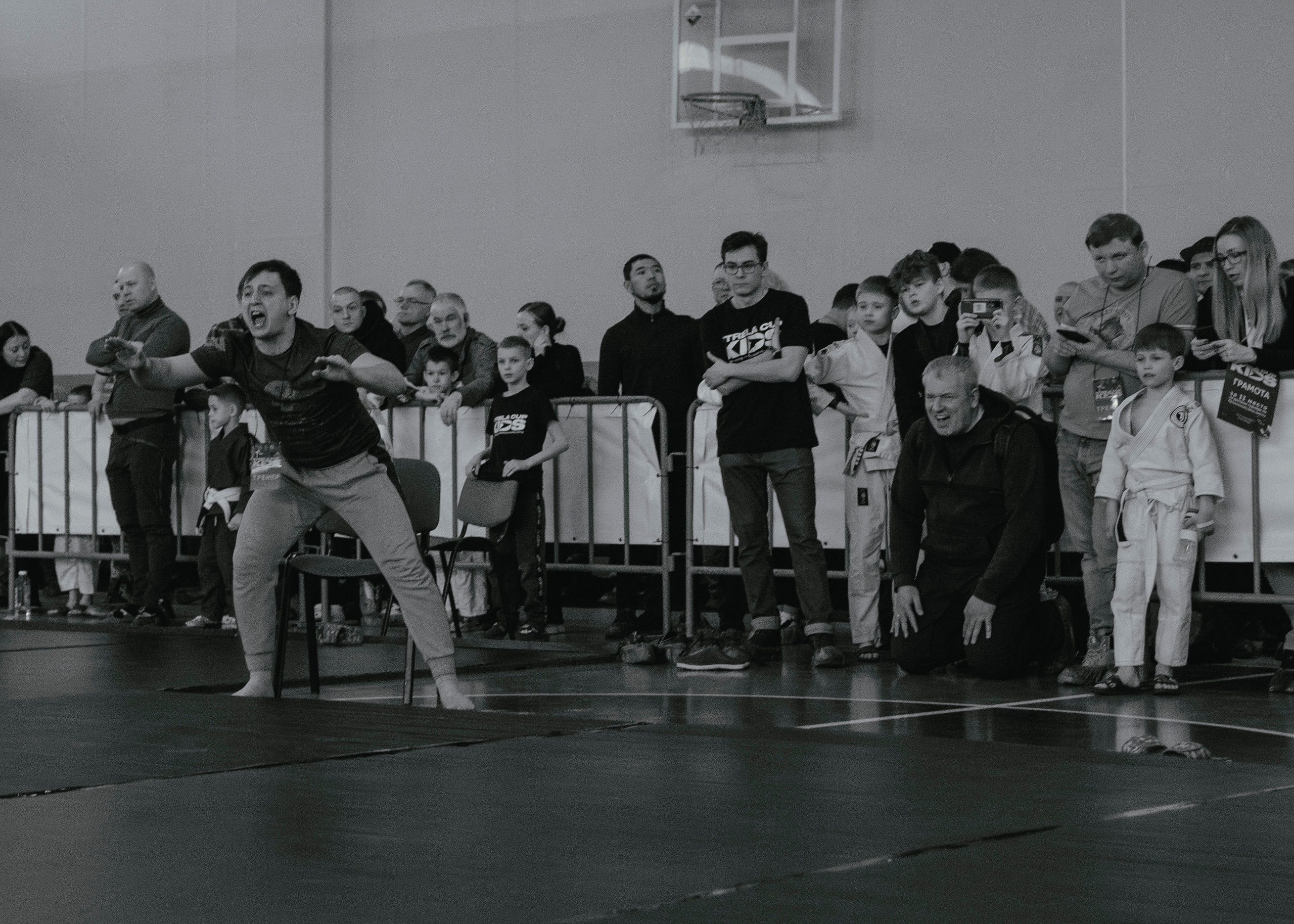 Тренер эмоционально кричит на детском турнире по джиу-джитсу.