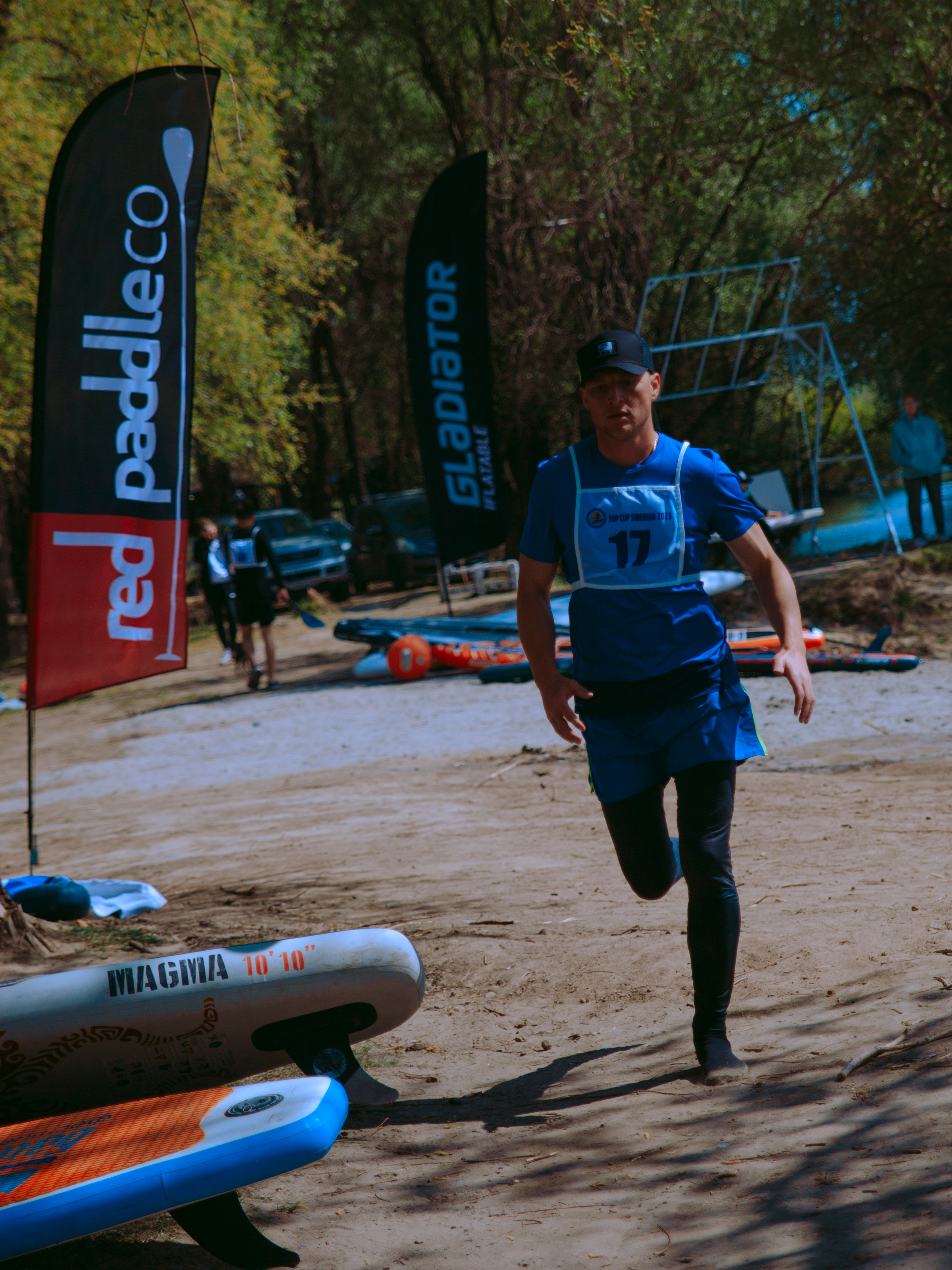 Спортсмен мужчина  бежит по берегу.