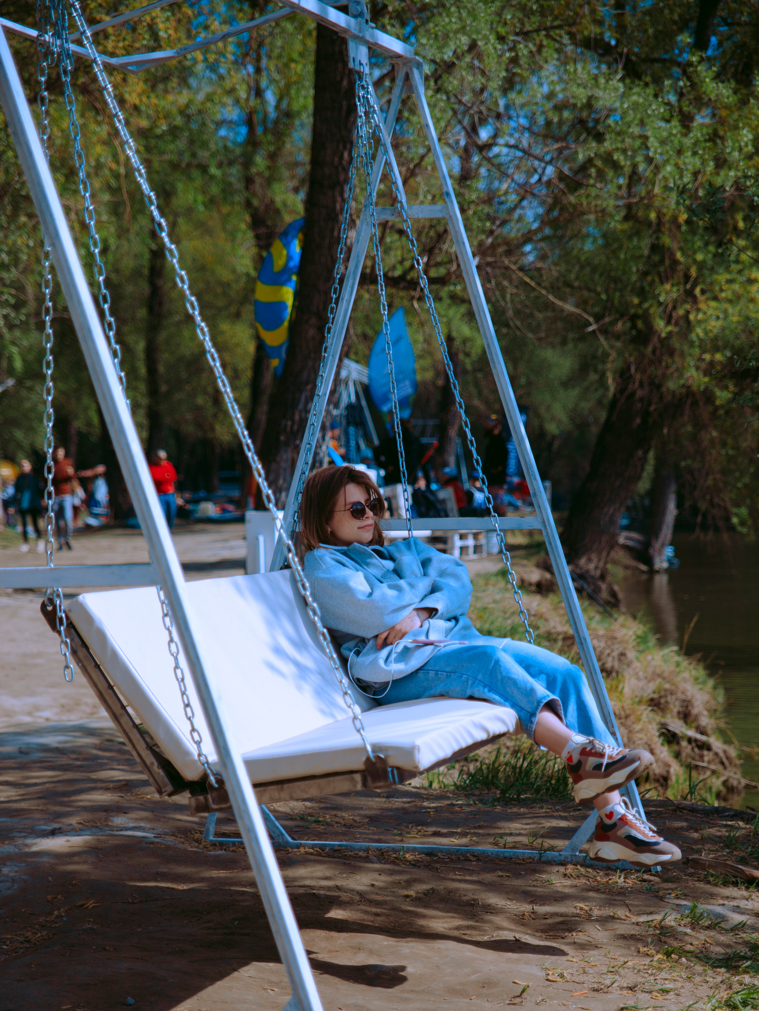 Девушка мечтает на качелях.