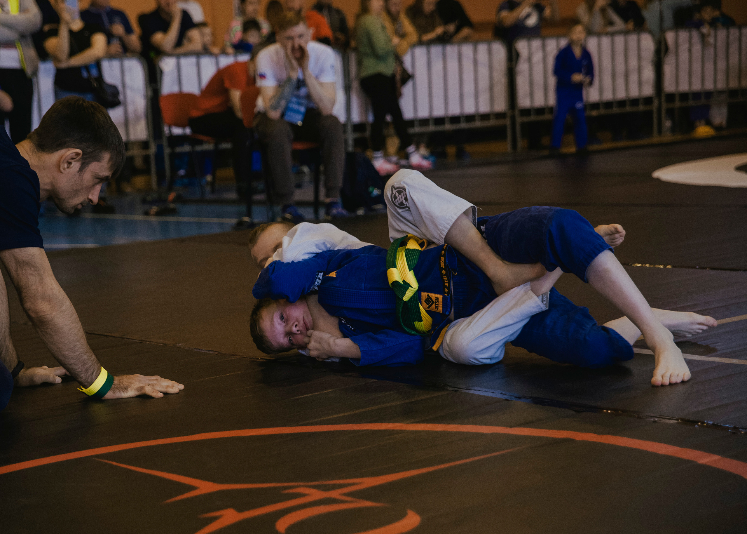 Борьба в кимоно gi на детском турнире по джиу-джитсу.