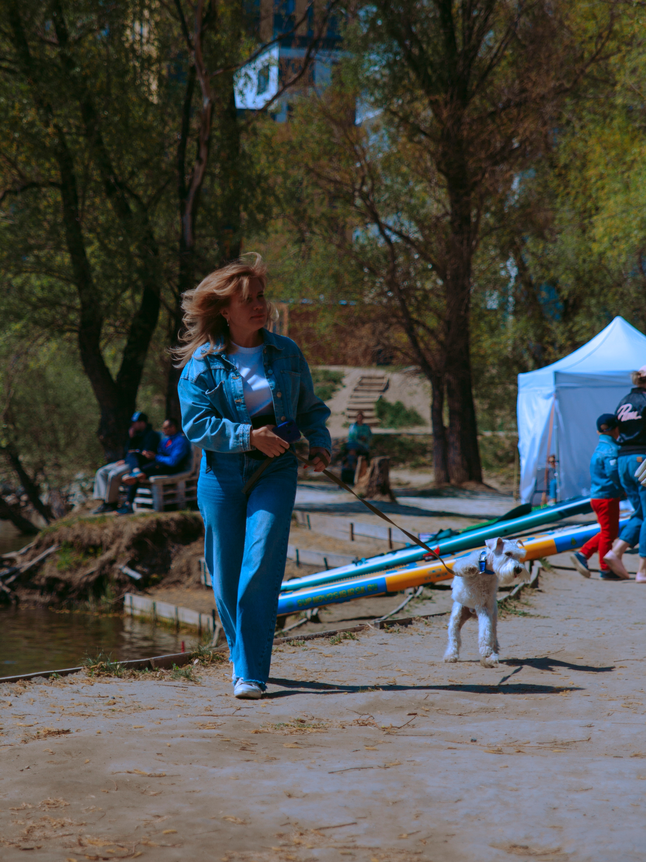 Женщина гуляет с маленькой собачкой.