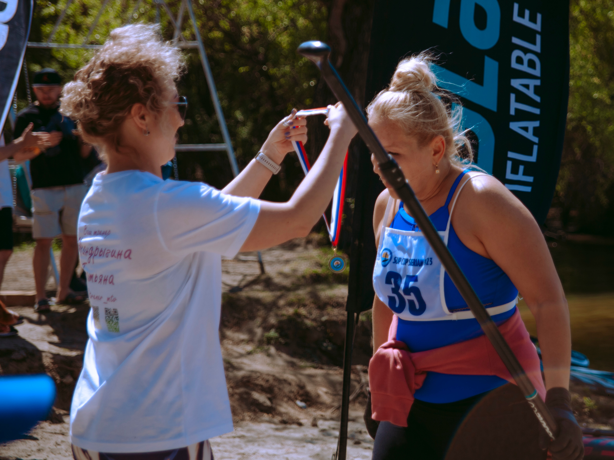 Женщина в возрасте получает медаль.
