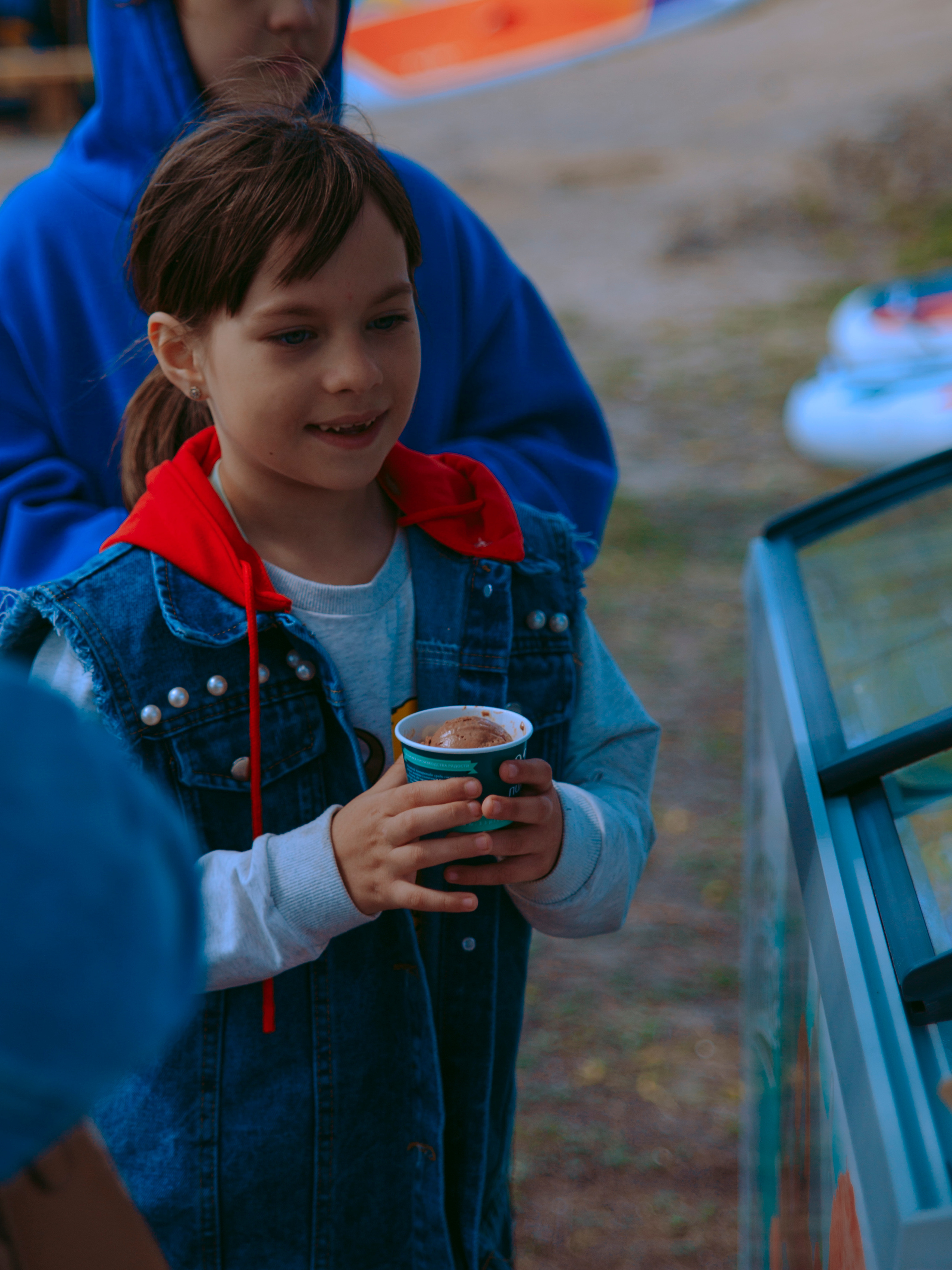 Ребенок со стаканчиком мороженого.