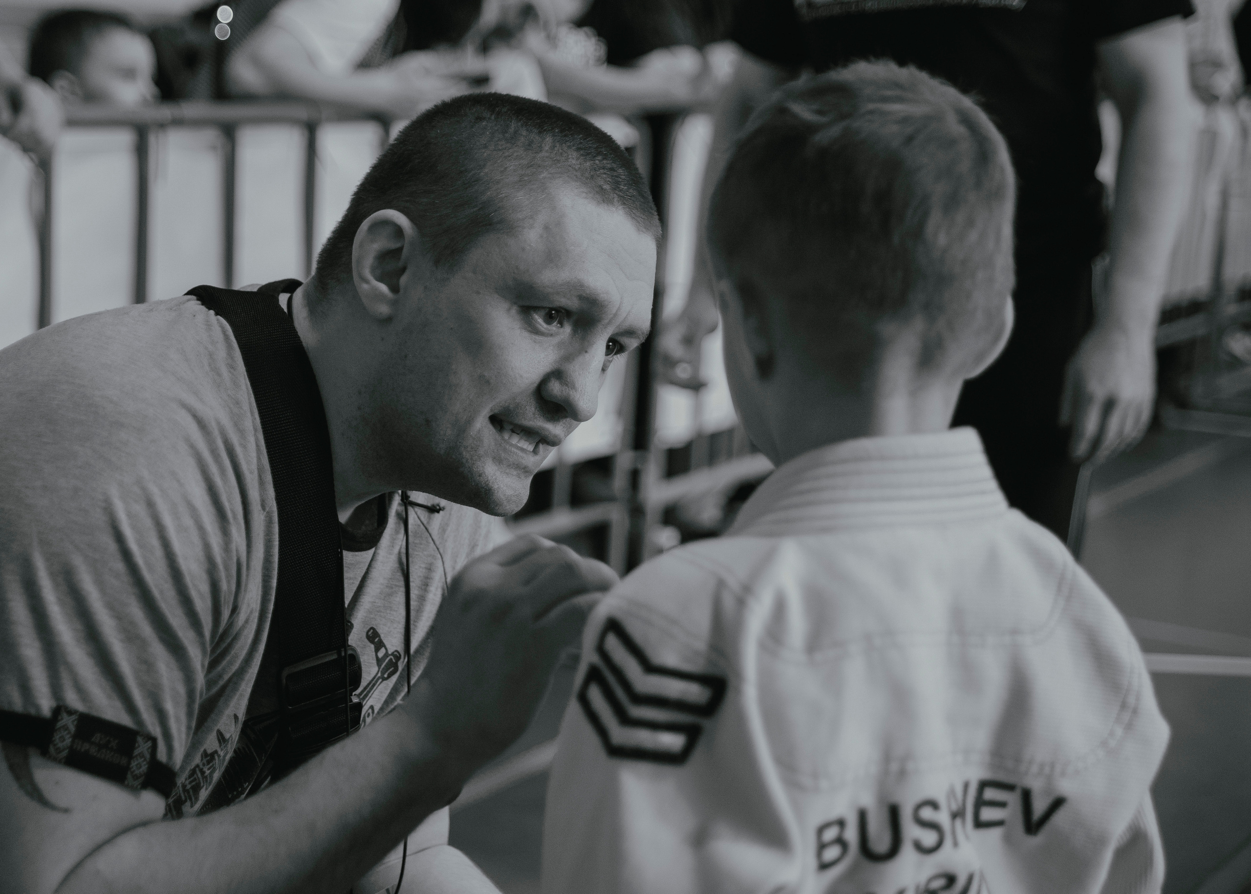 Тренер дает указания и советы своему подопечному спортсмену на детском турнире по джиу-джитсу.