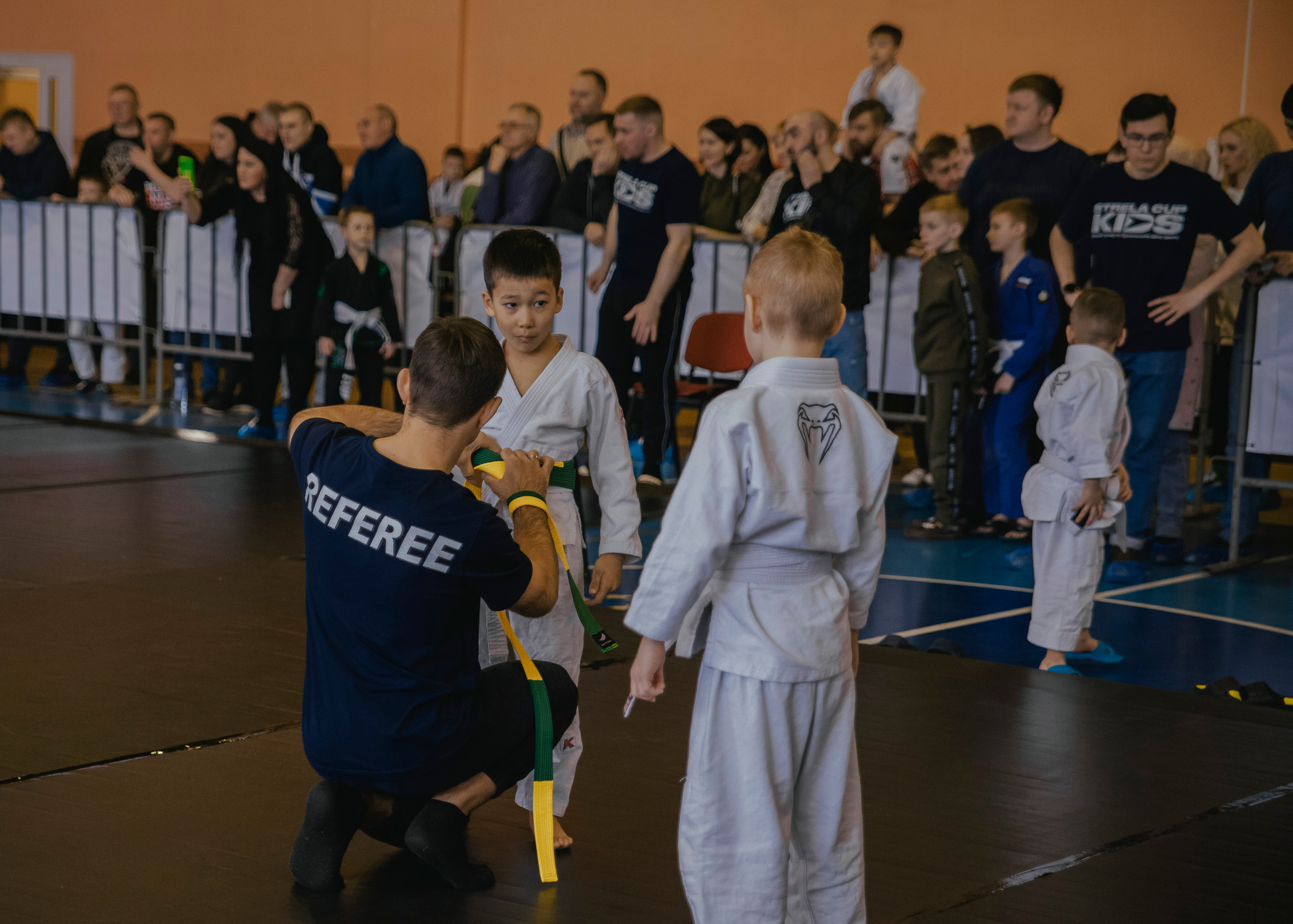 Дети и судья на детском турнире по джиу-джитсу.