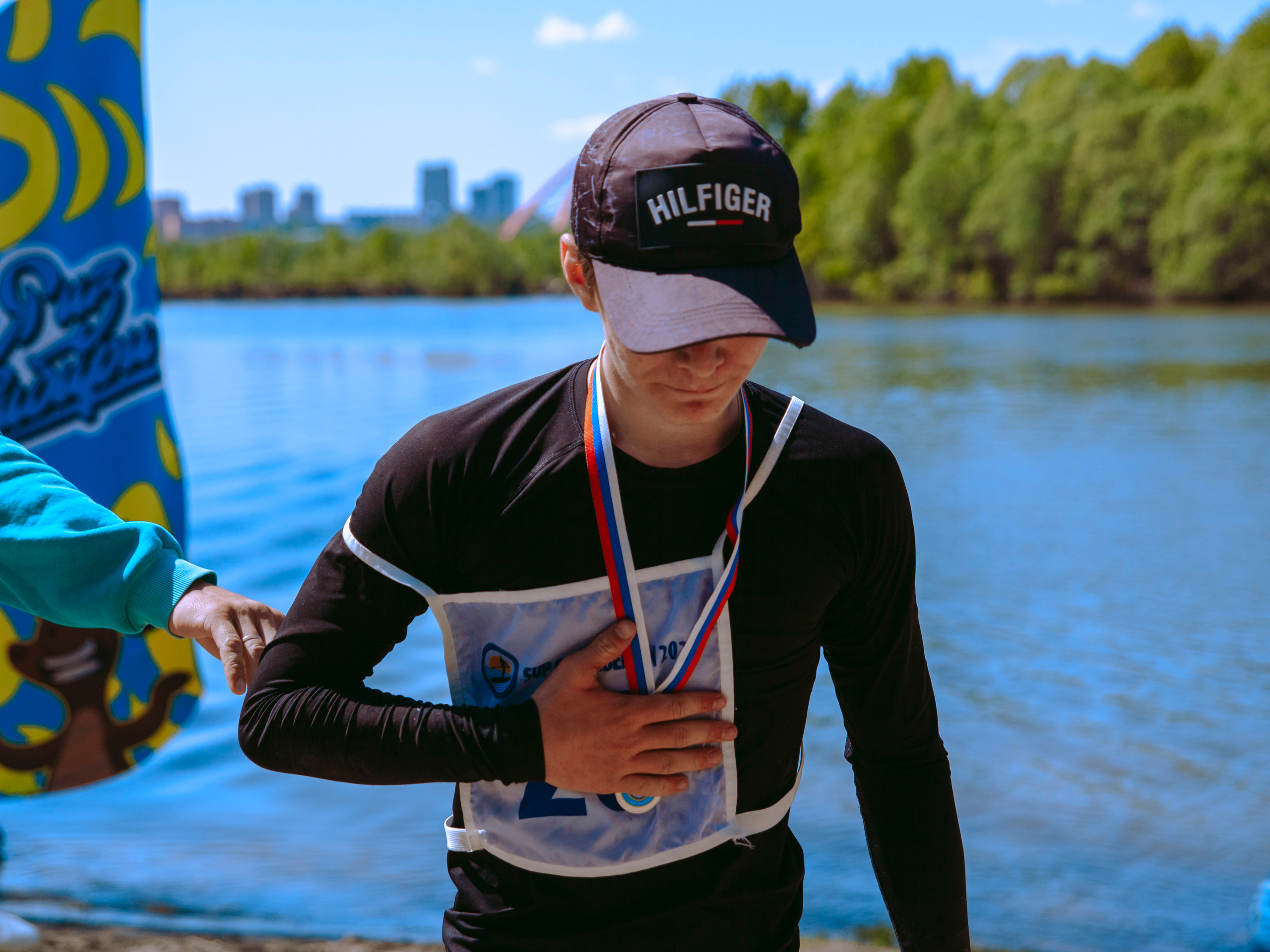 Парень получает медаль и прижимает ее к груди.