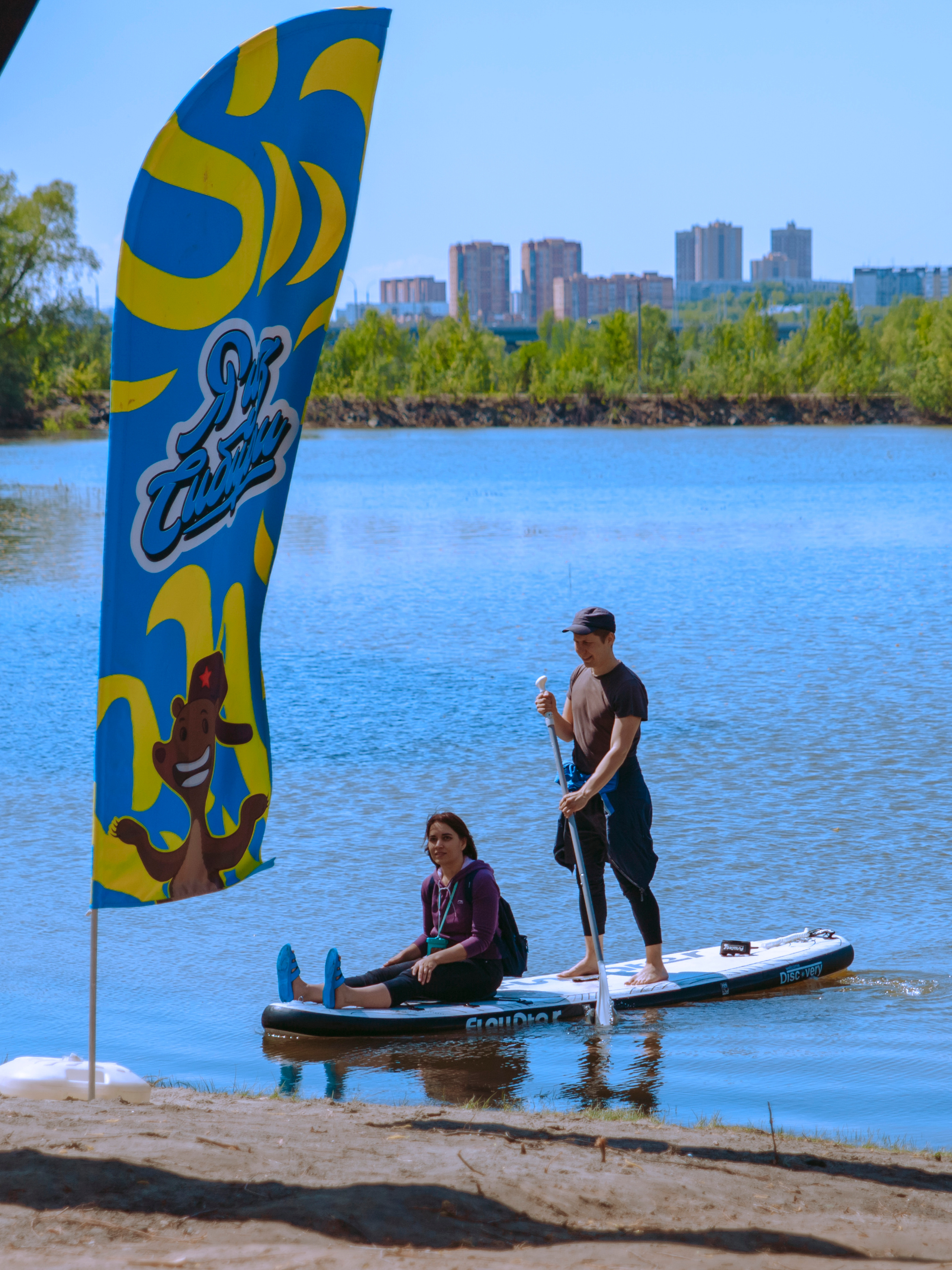 Мужчина катает девушку на сапе.