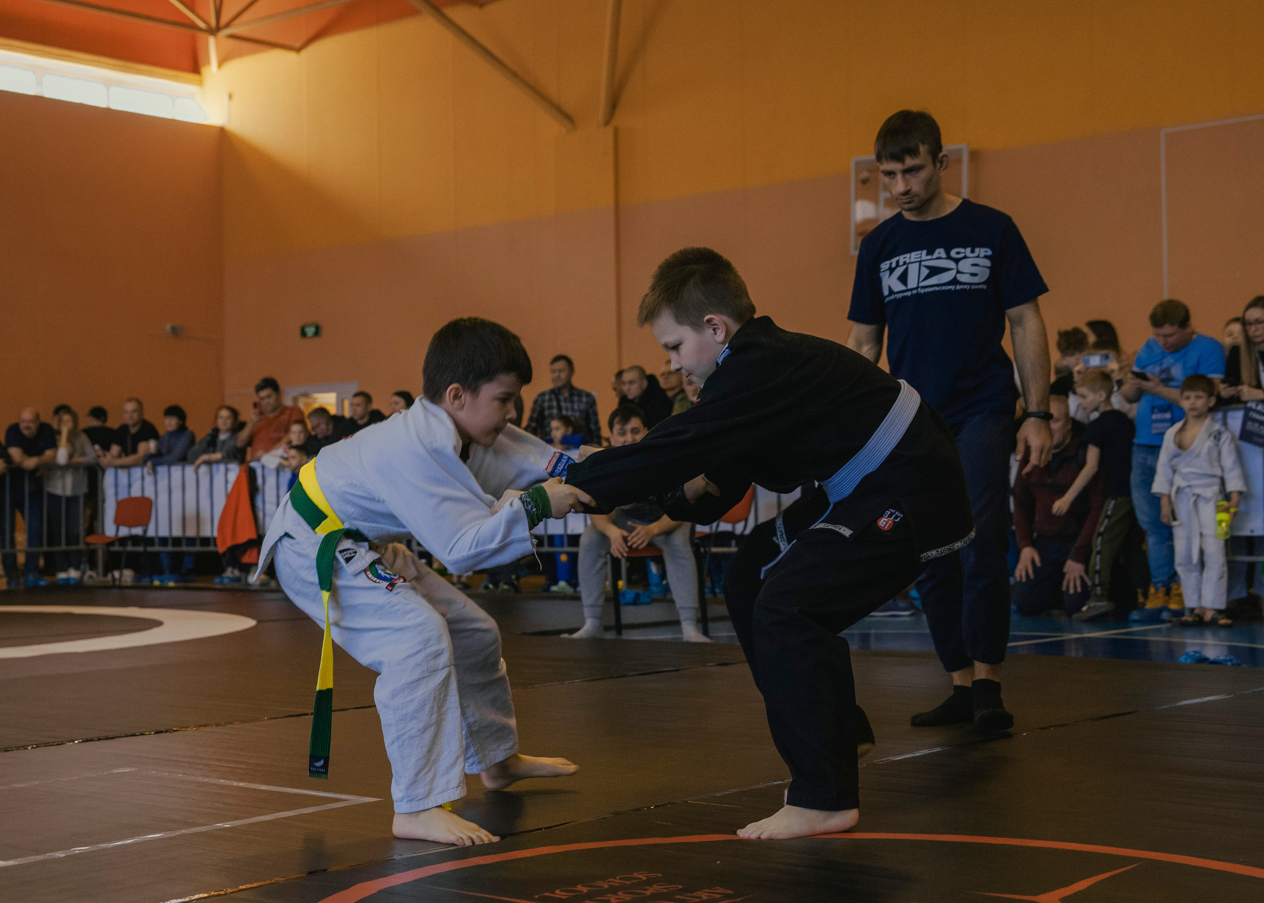 Борьба в кимоно gi на детском турнире по джиу-джитсу.