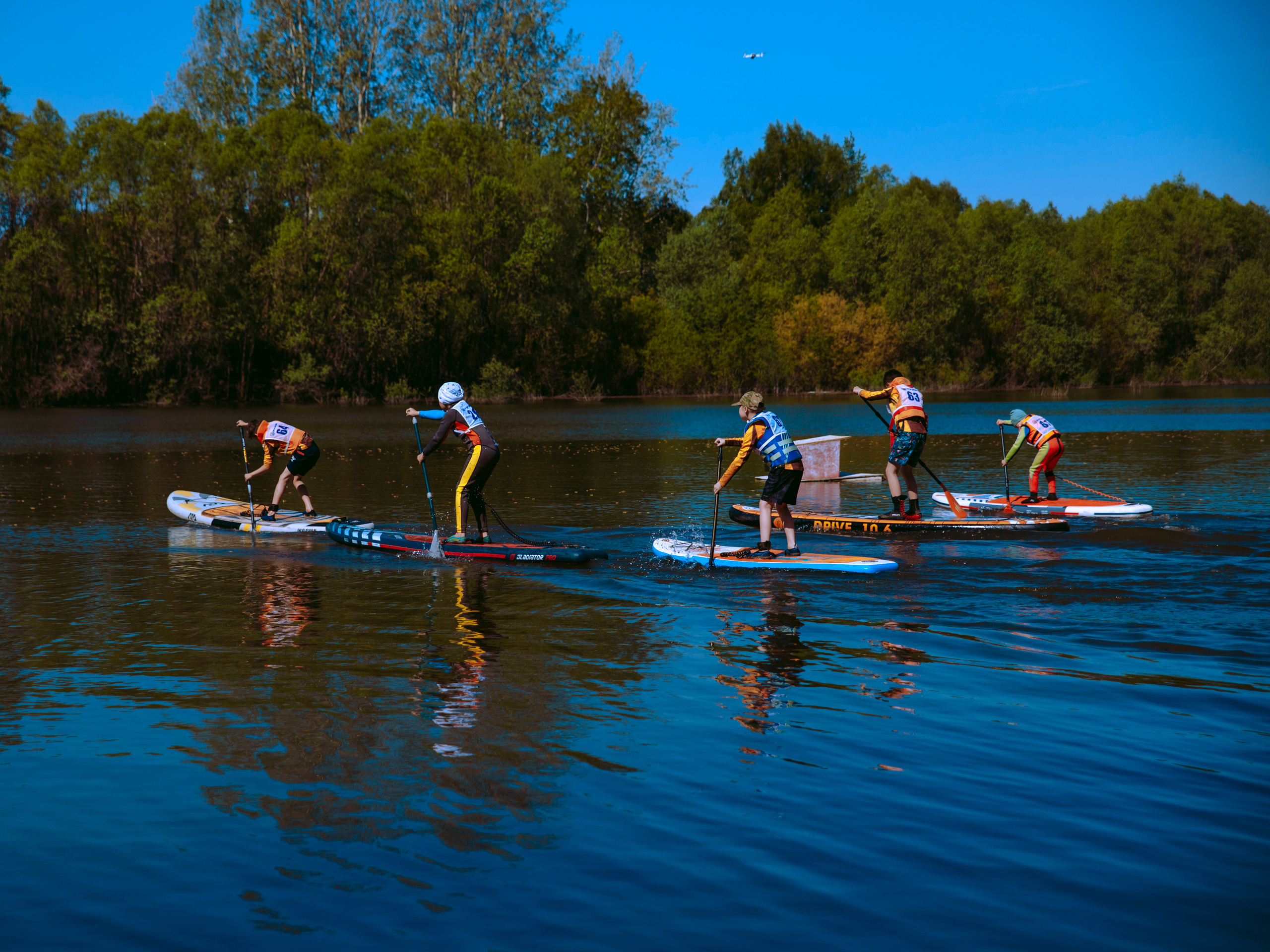 Дети плывут на сапах.
