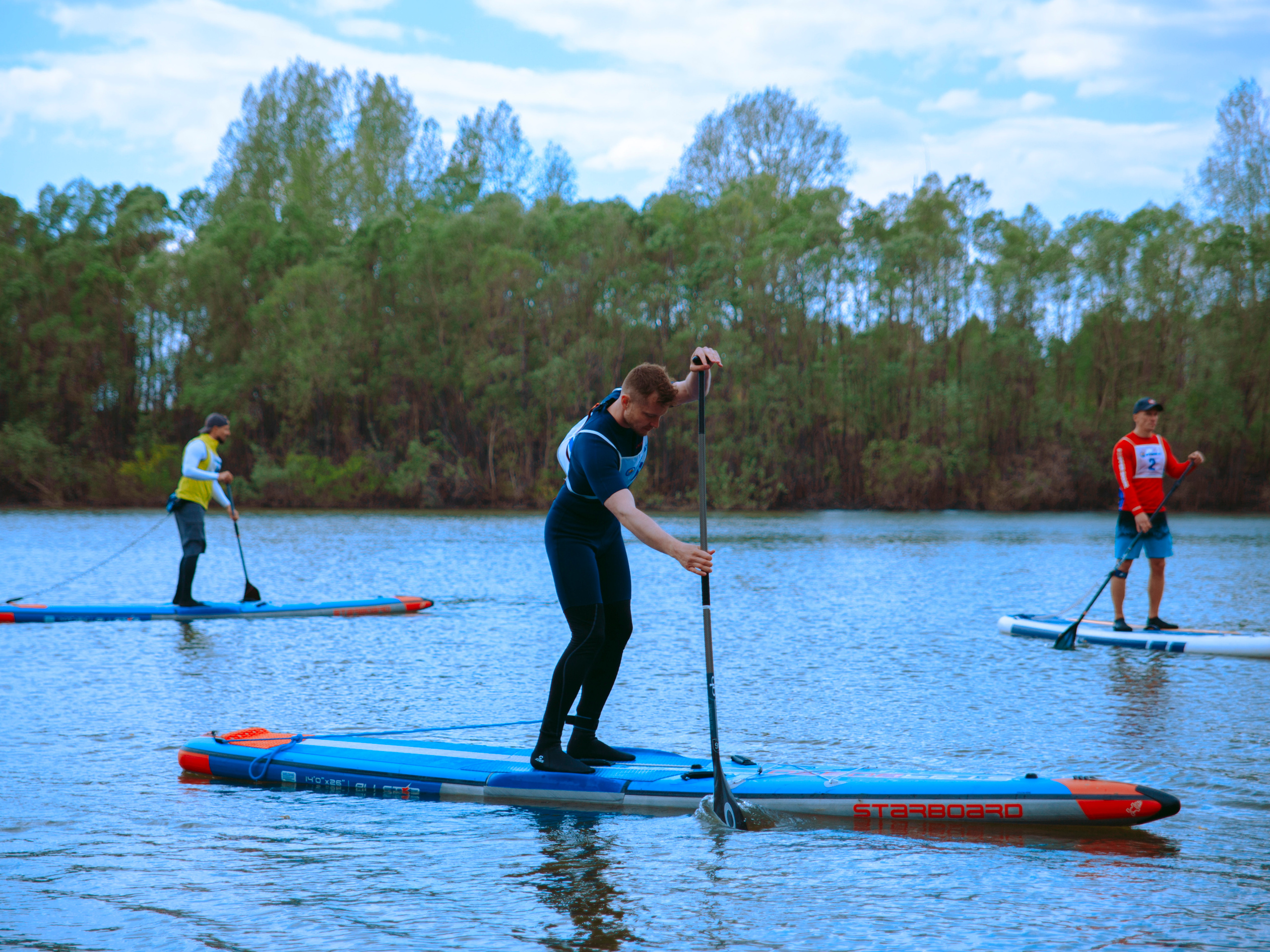 Мужчины плывут на сапах в Новосибирске по Оби.