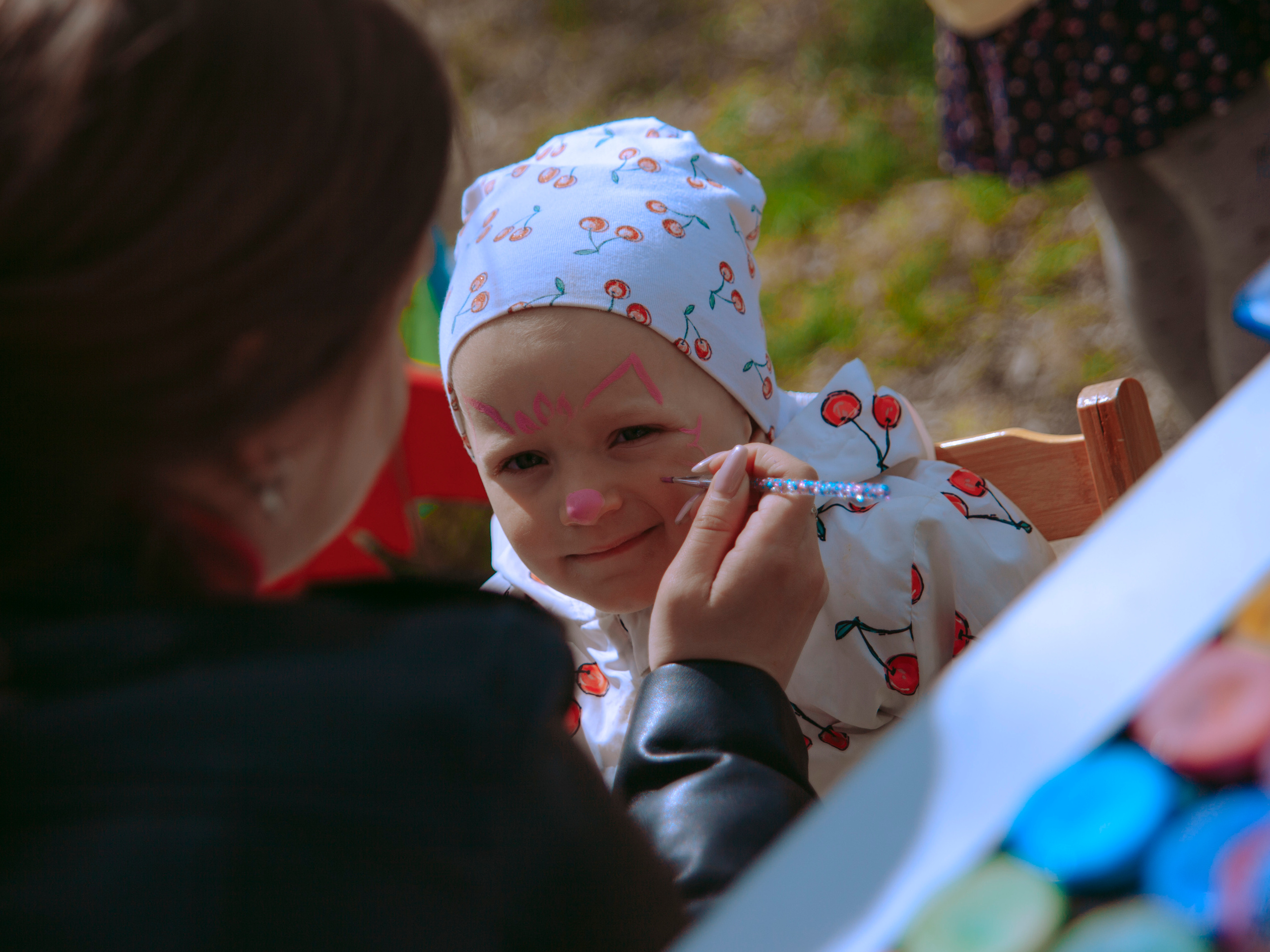 Ребенку рисуют на лице.