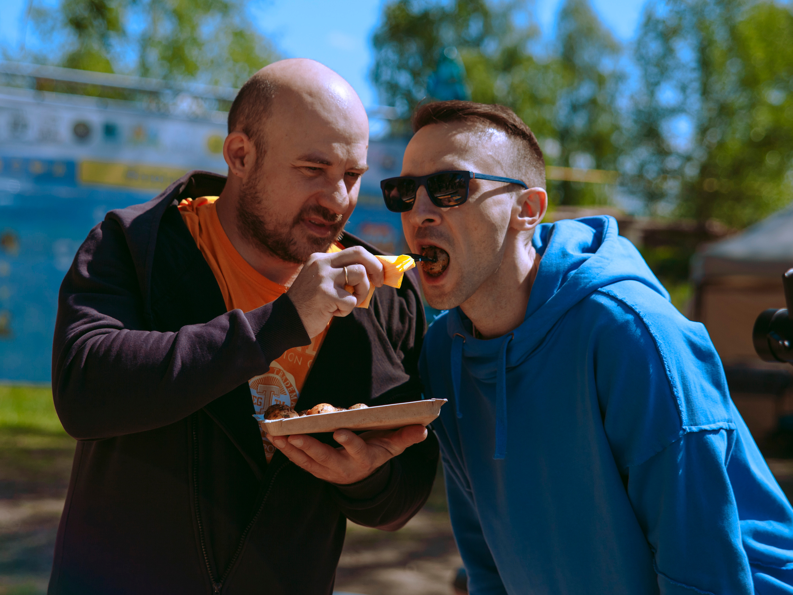 Лысый мужчина кормит мясом своего друга.