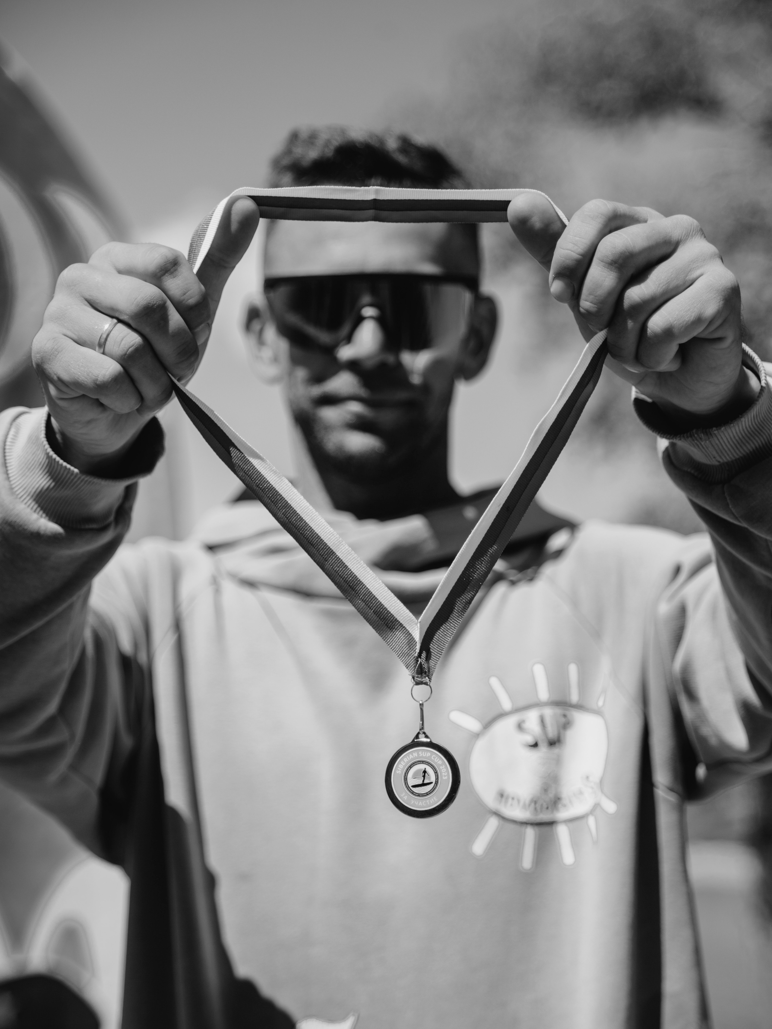 Мужчина показывает медаль в камеру.