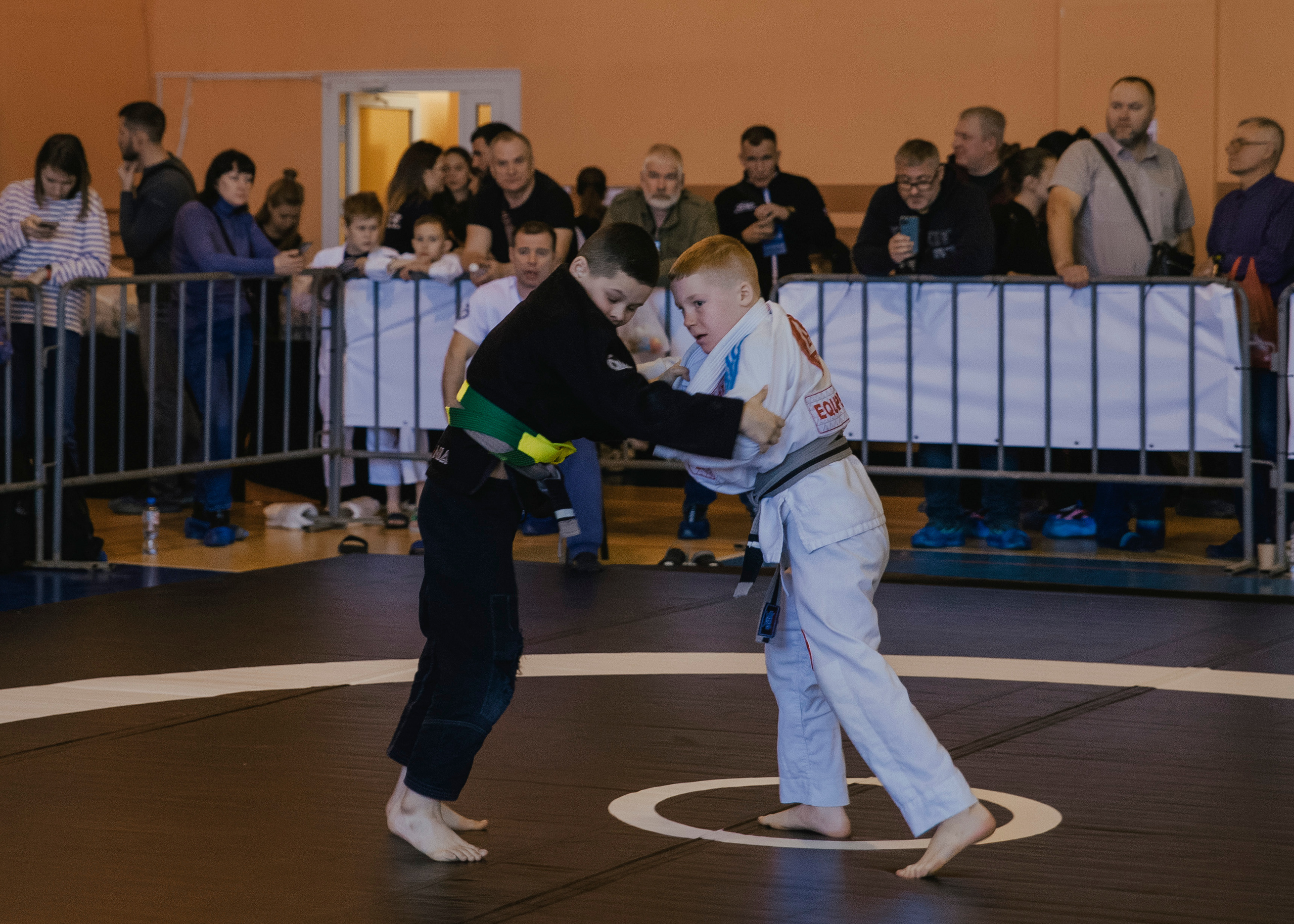 Борьба в кимоно gi на детском турнире по джиу-джитсу.