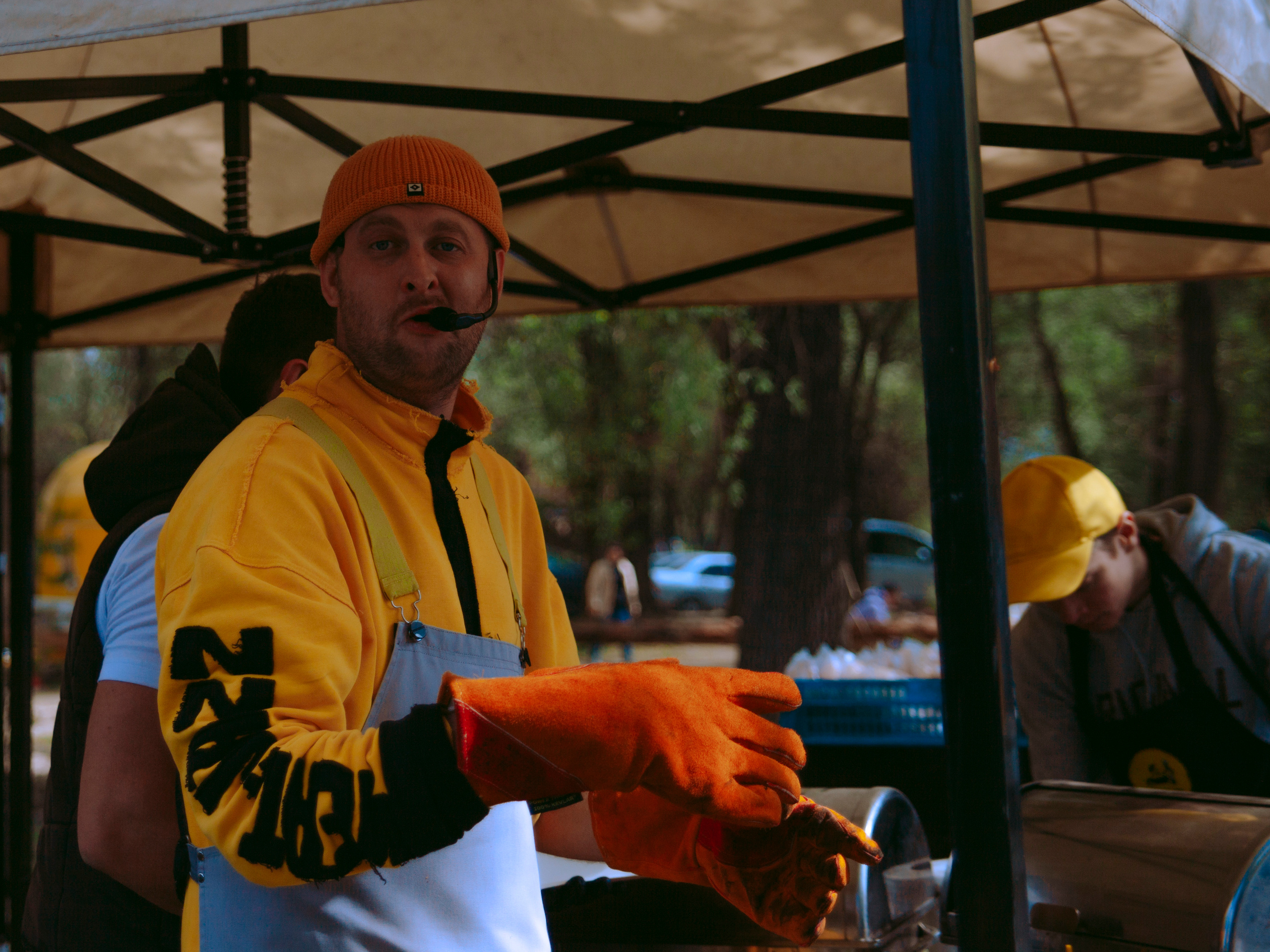 Мужчина с микрофоном жарит шашлык.