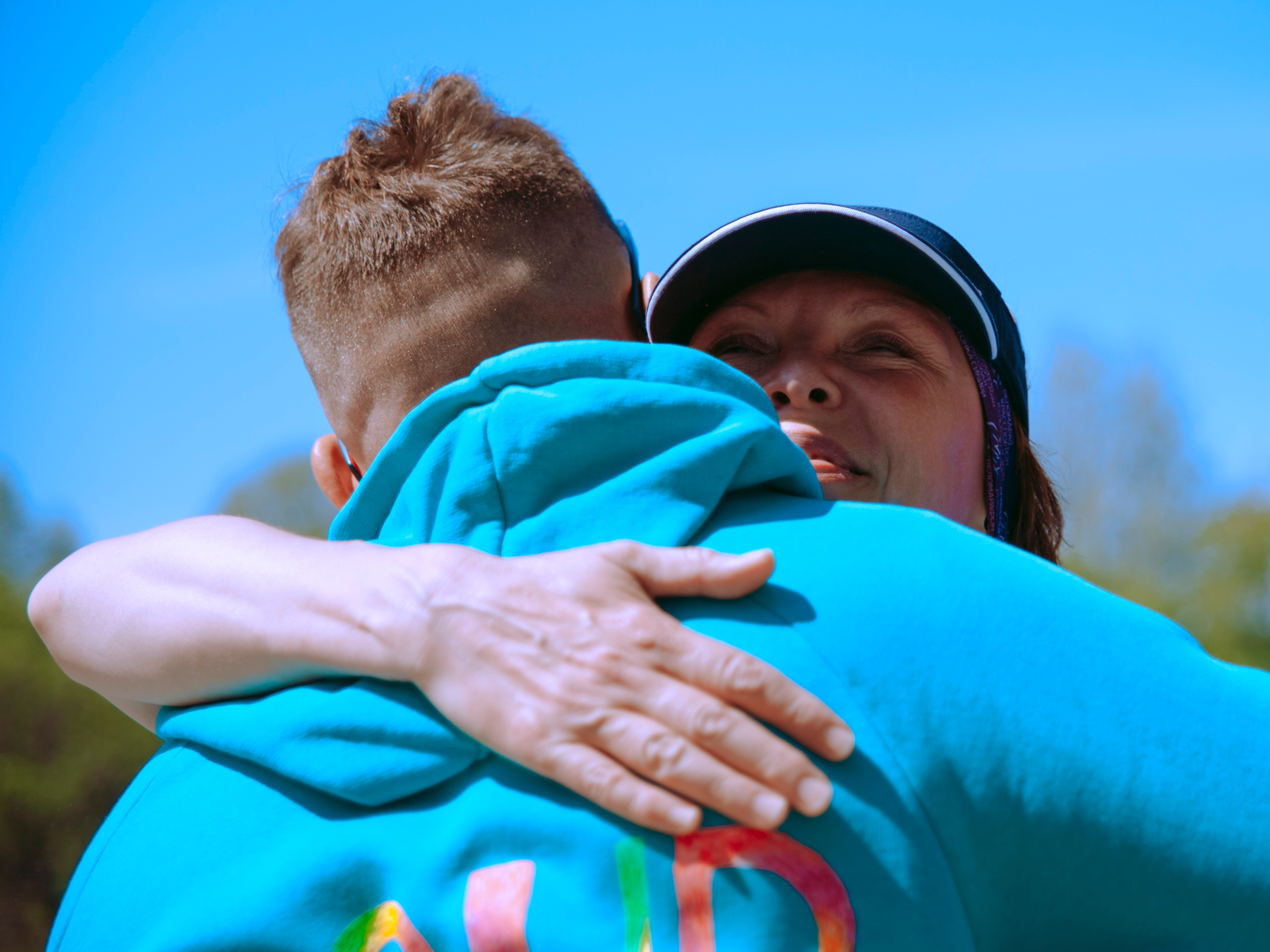 Женщина спортсменка обнимает тренера.