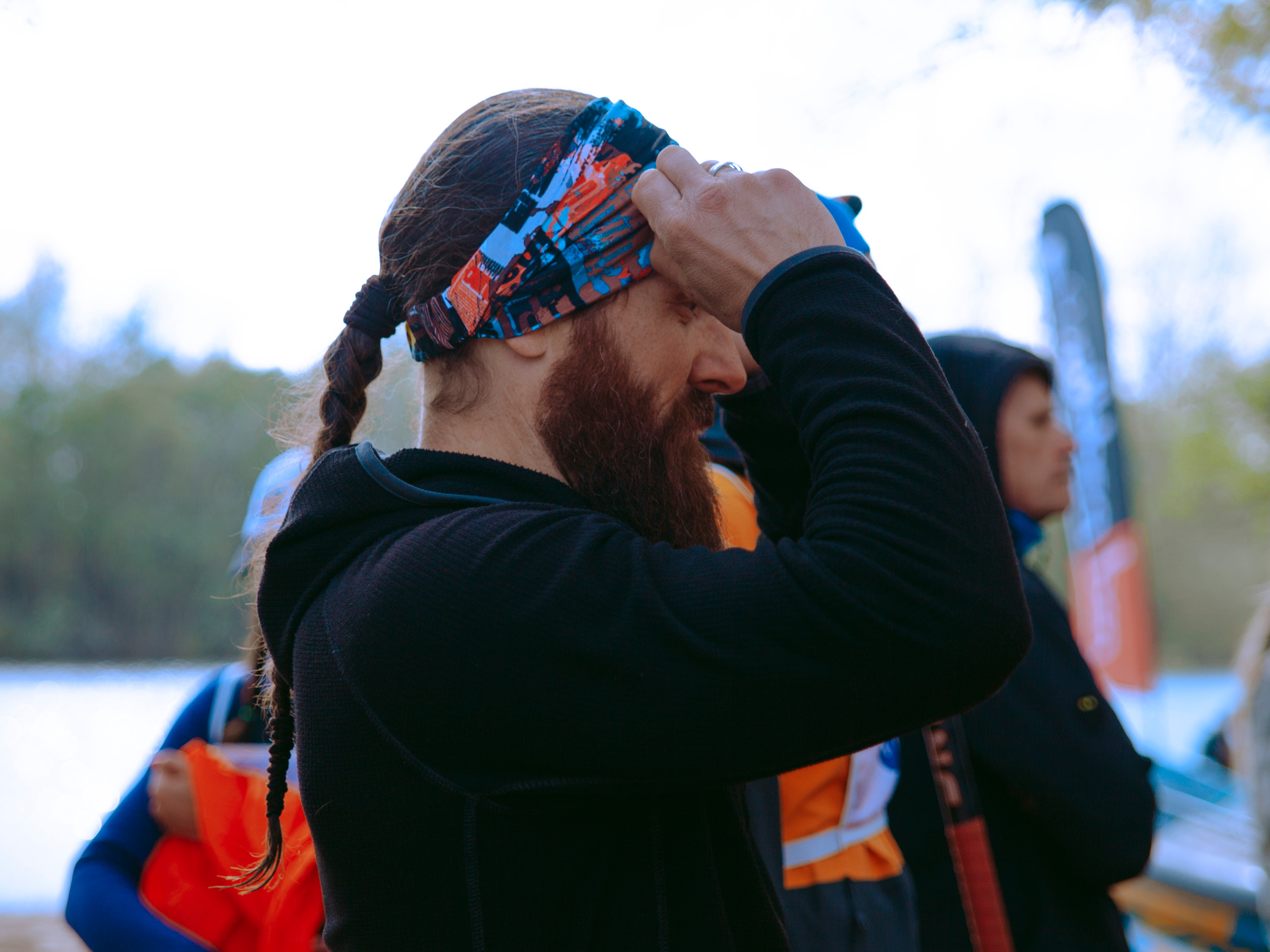 Мужчина поправляет повязку на голове.