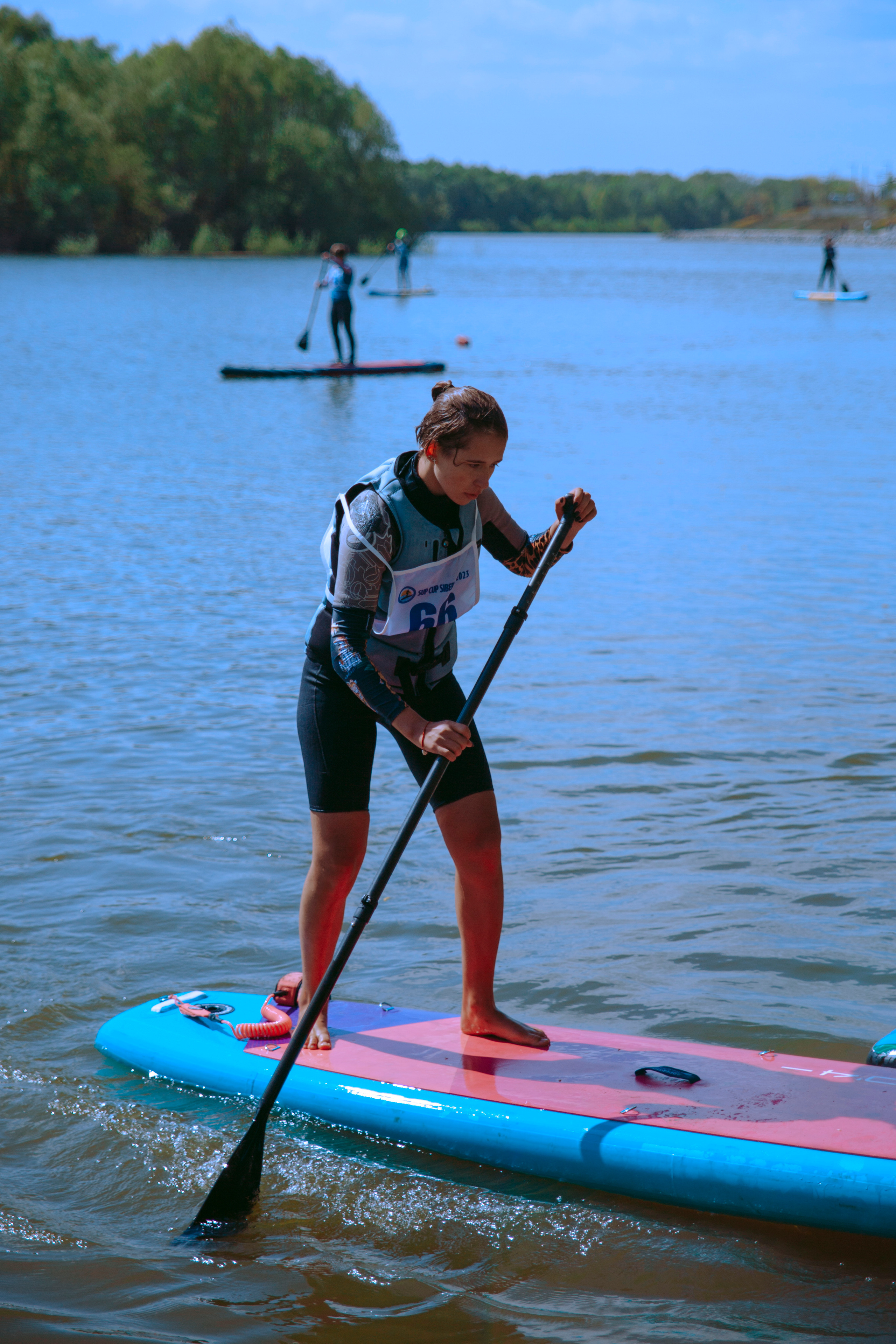 Девушка гребет веслом на сапе.