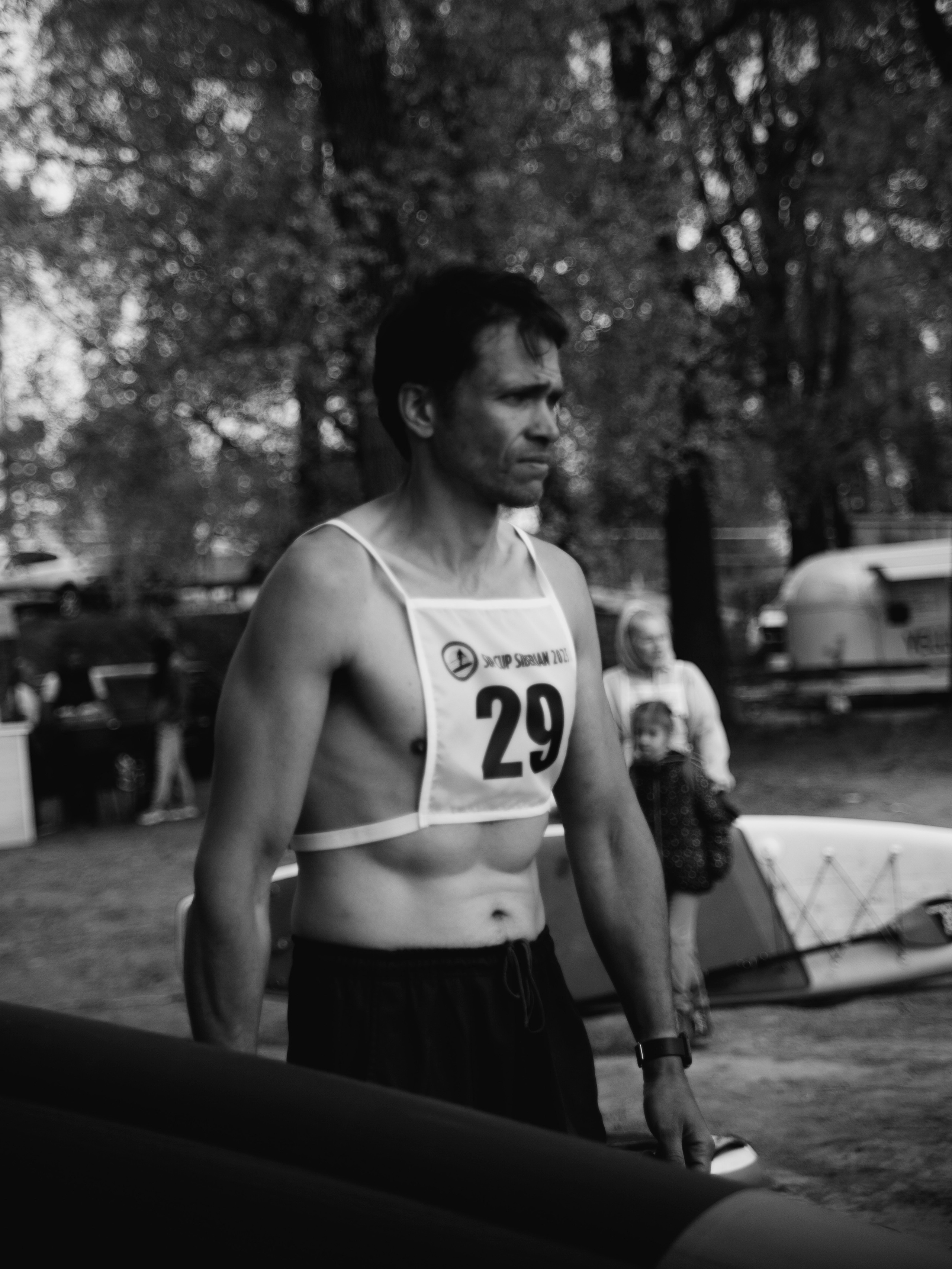 Мужчина спортсмен с номером на груди и голым торсом.