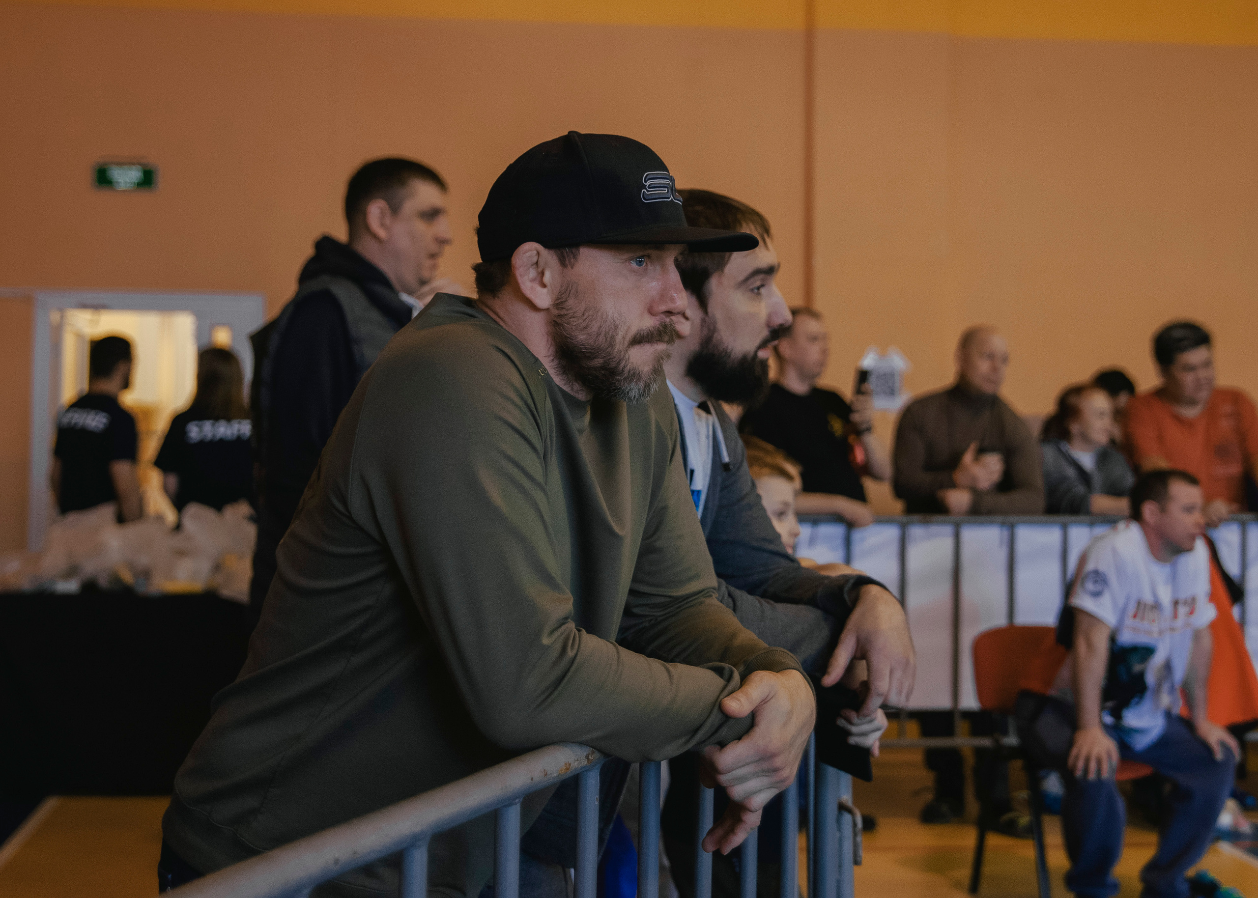 Взрослые болельщики организаторы на детском турнире по джиу-джитсу.