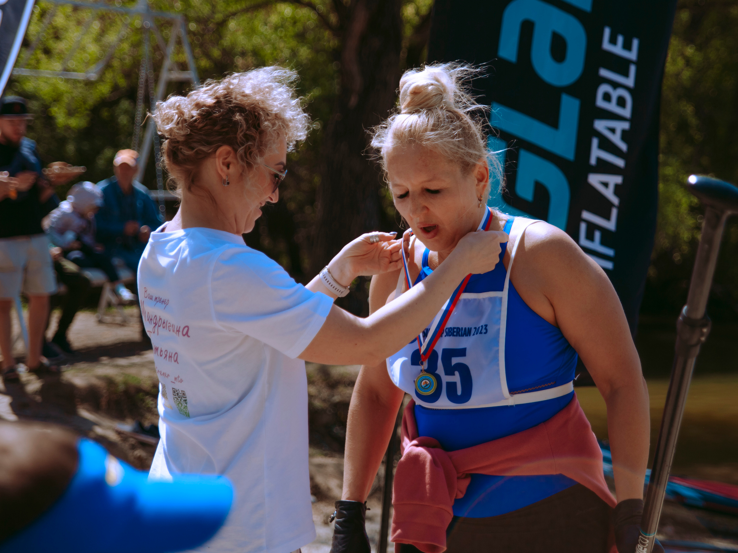 Женщина в возрасте получает медаль.