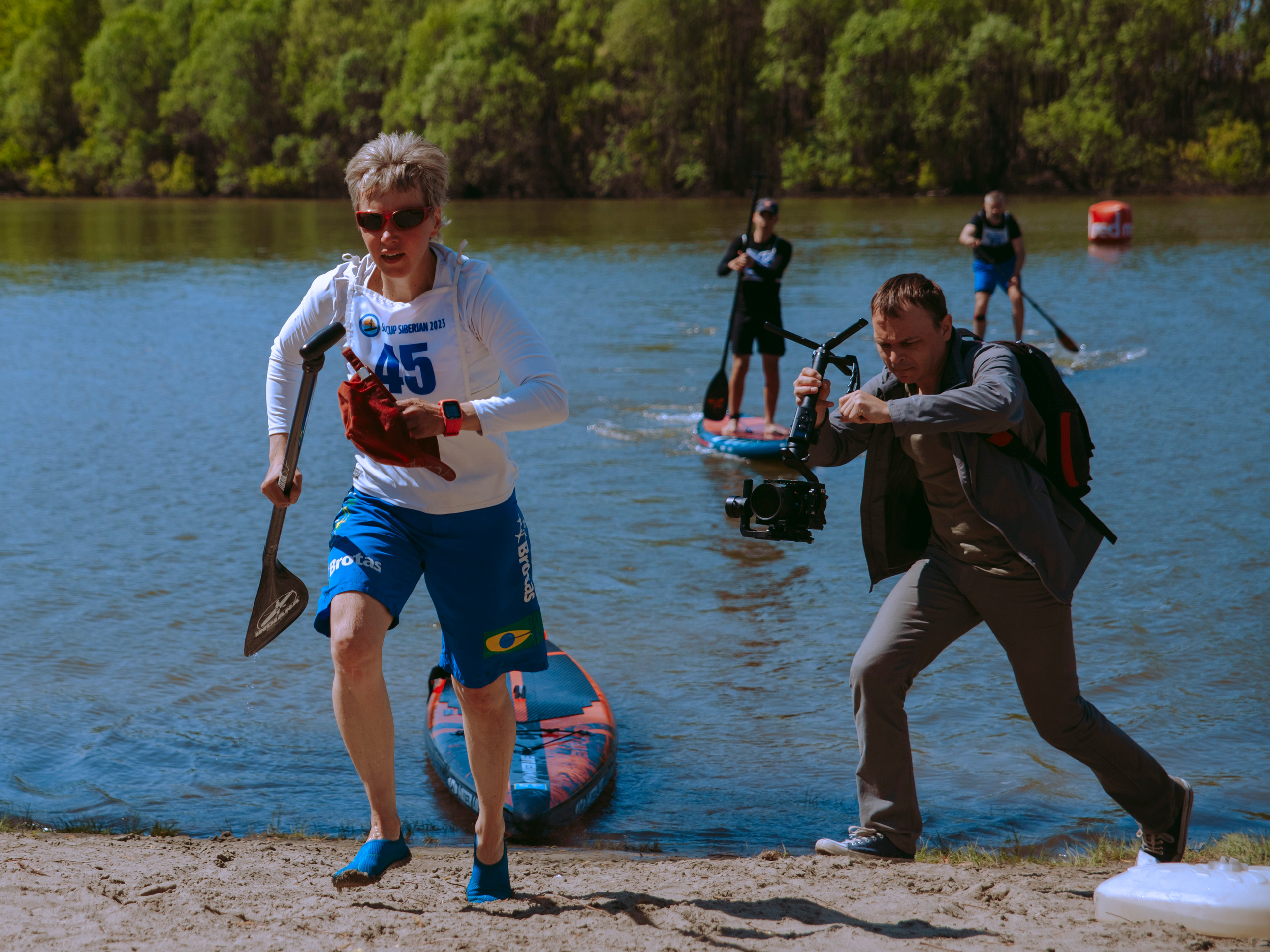 Видеооператор бежит за спортсменом.