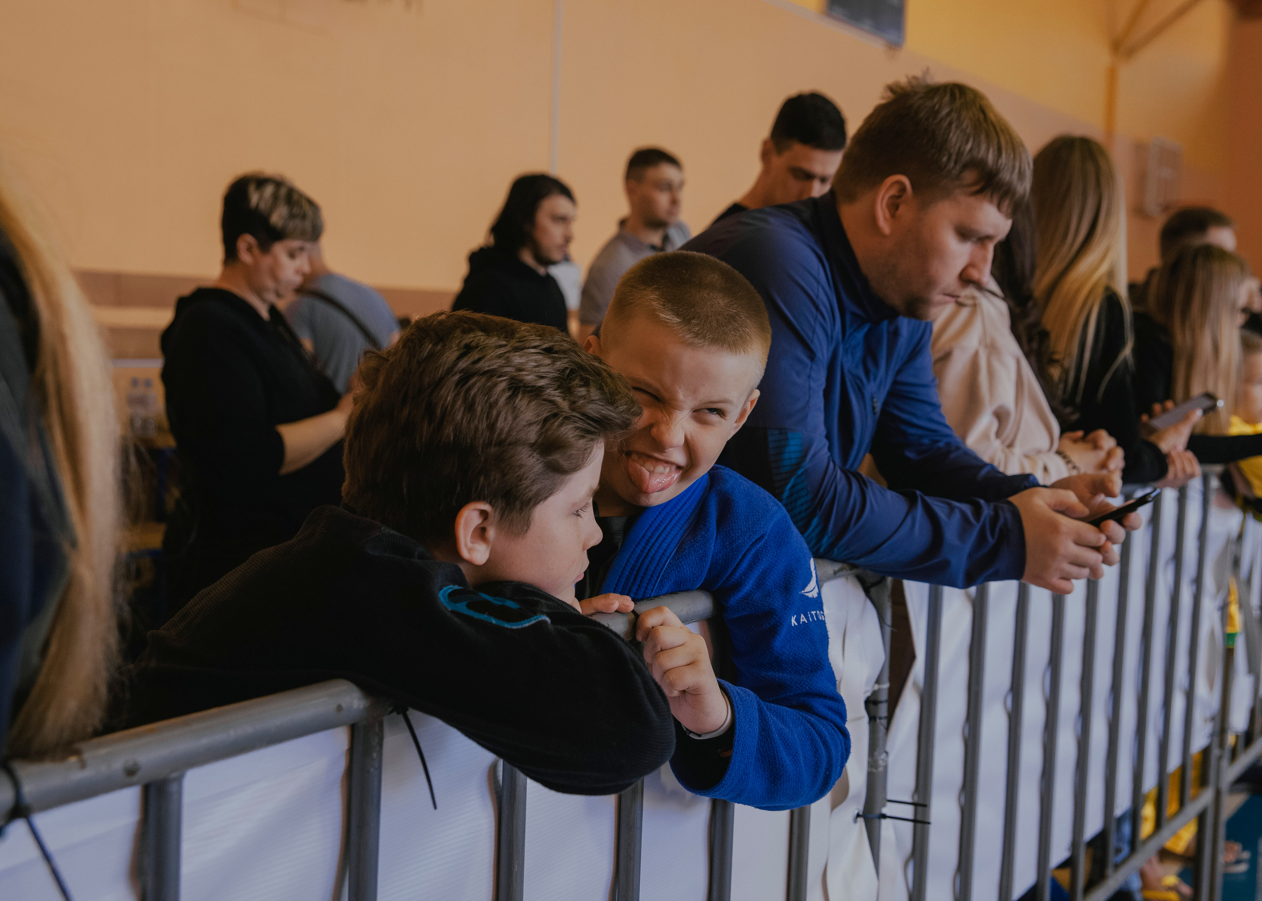 Ребенок дурачится и кривляется и показывает язык на детских спортивных соревнованиях.