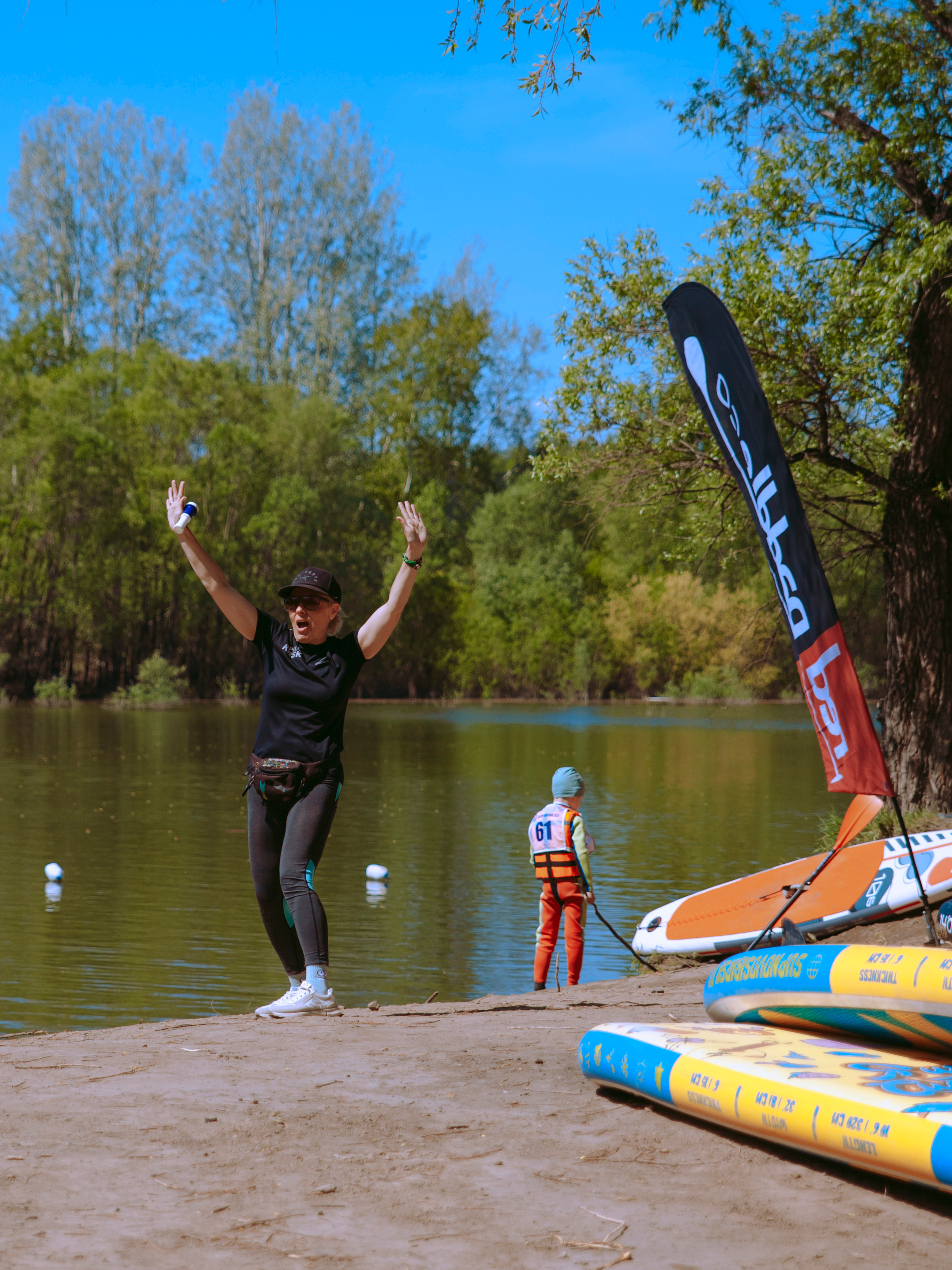 Женщина поддерживает спортсмено, подняв руки.