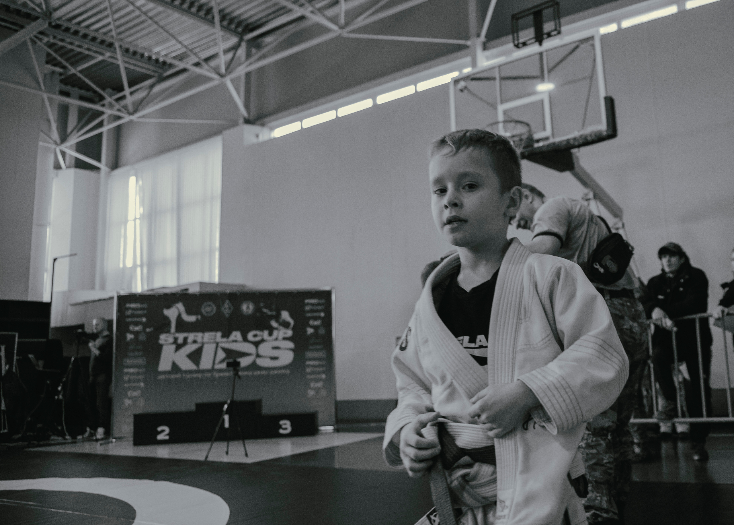 Ребенок бежит на детском турнире по джиу-джитсу.