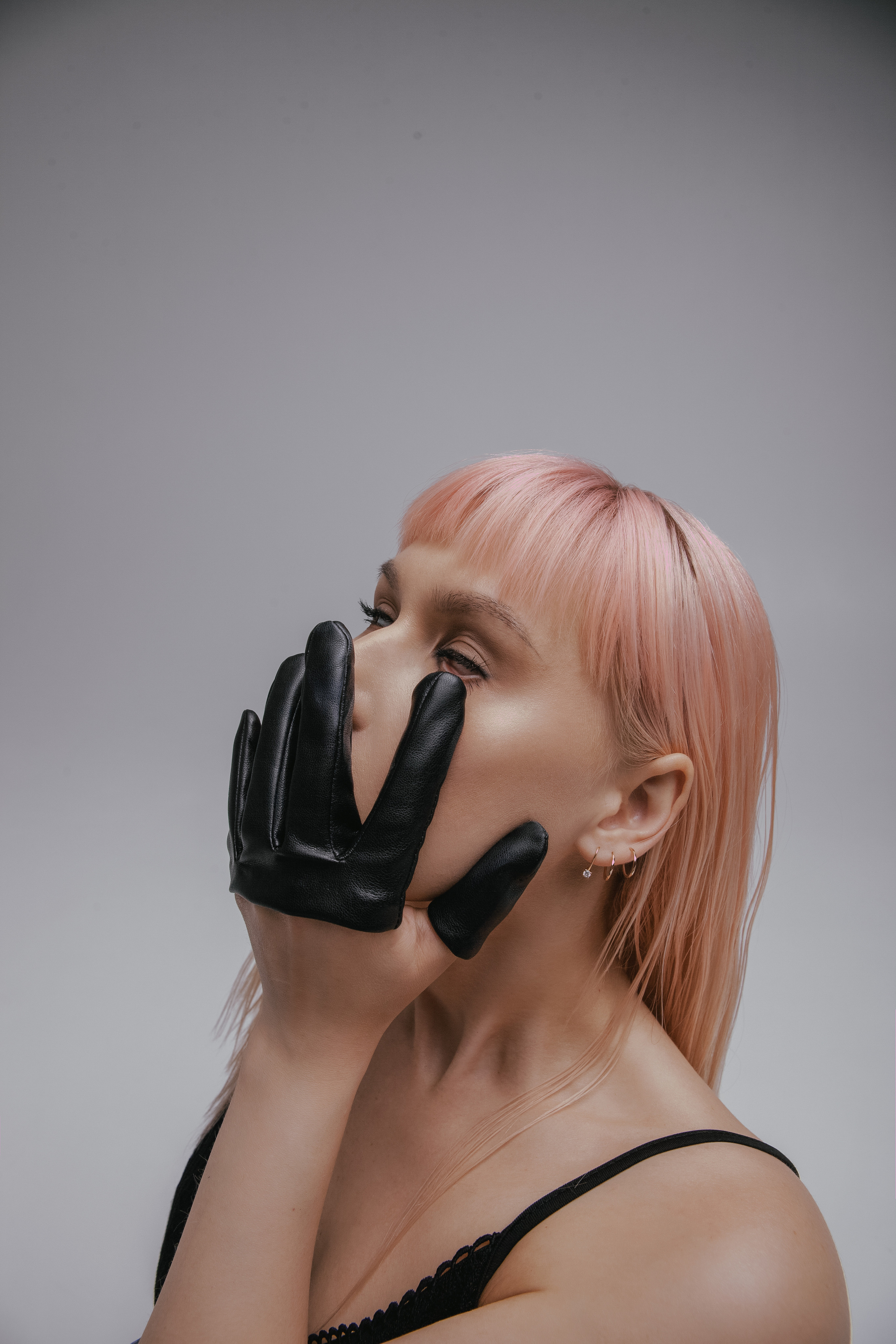 Девушка в перчатке пальцах Гуччи трогает лицо и закатывает глаза.