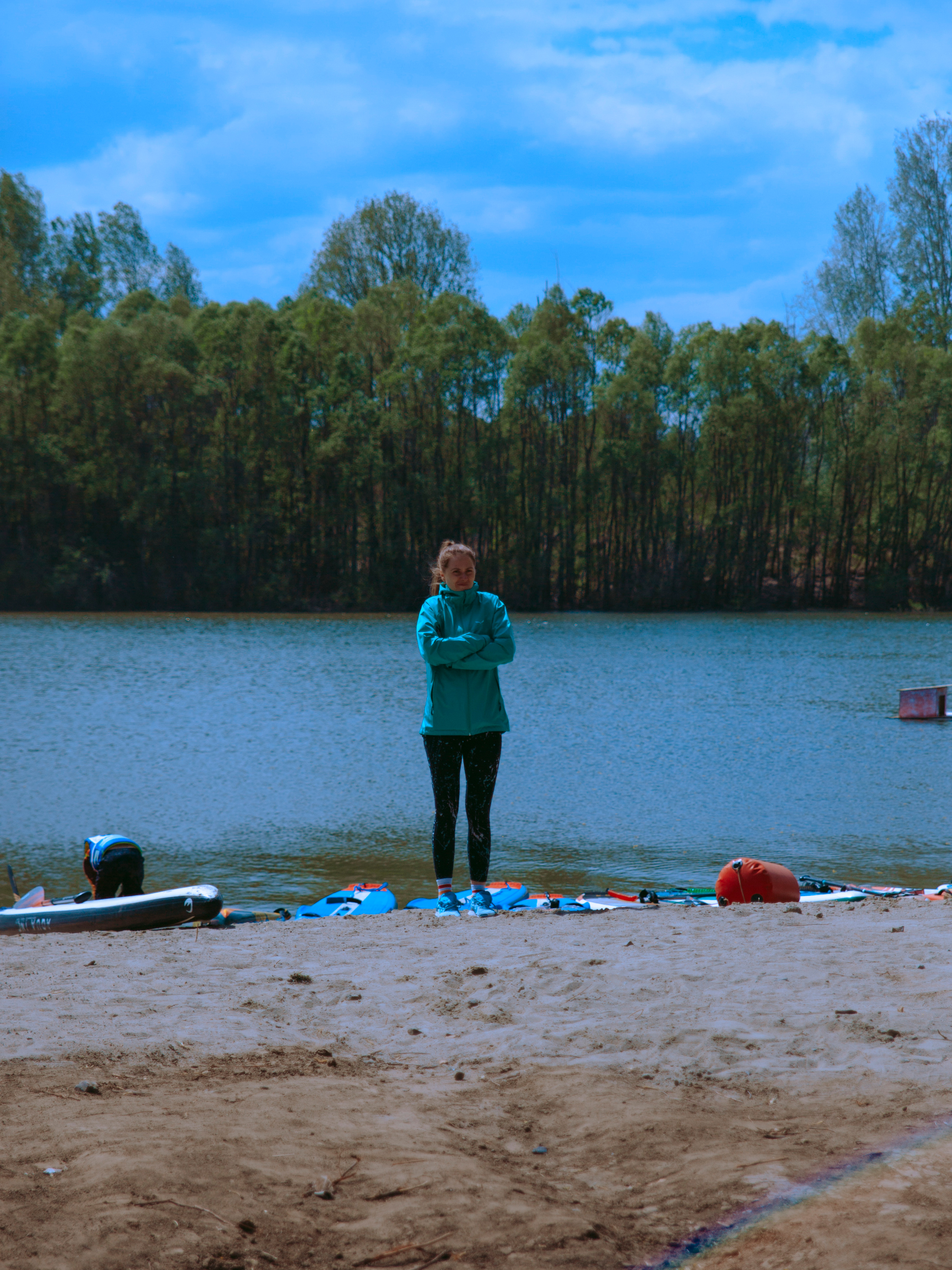 Девушка мерзнет на берегу.