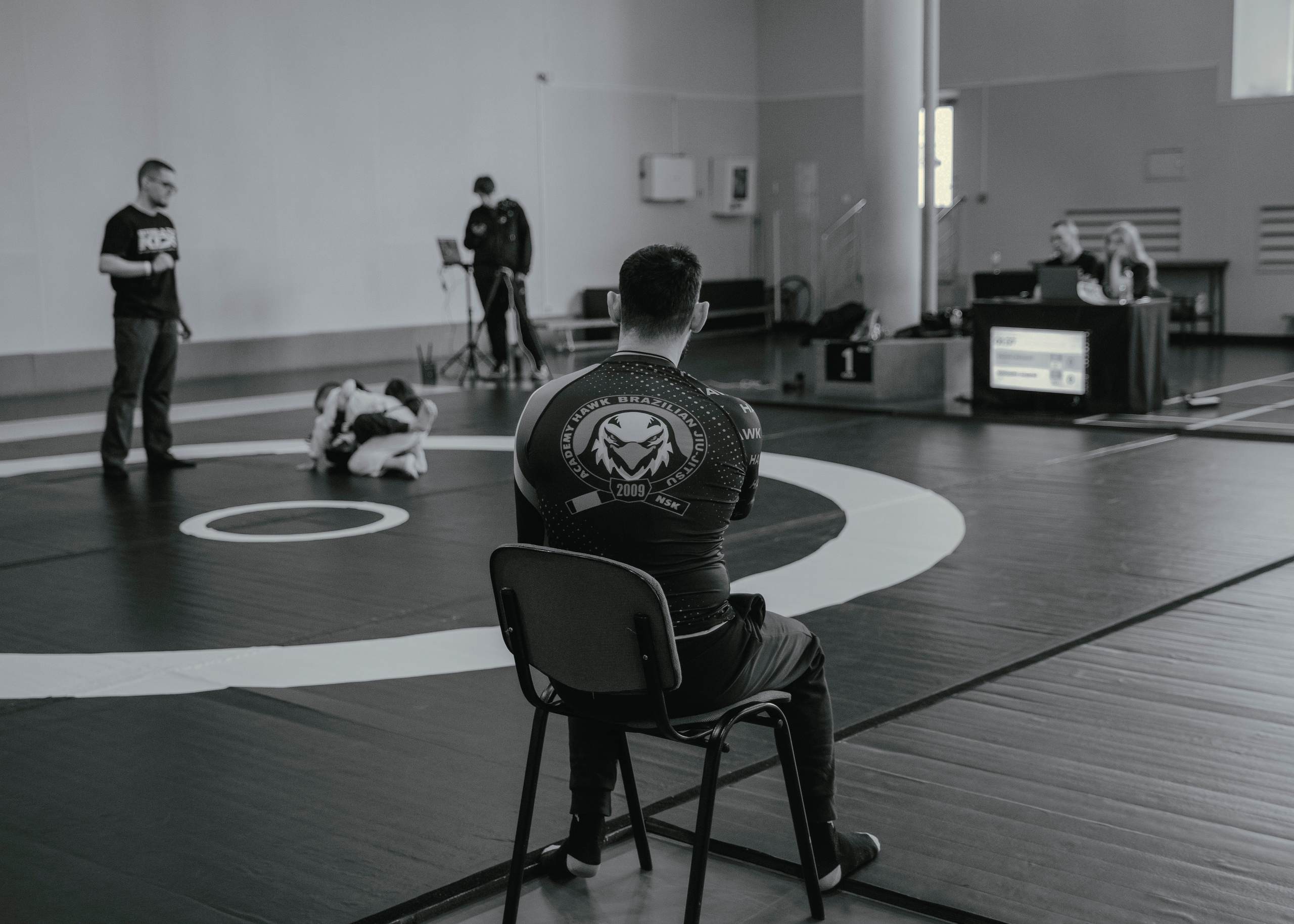 Тренер секундант в углу ковра на спортивных соревнованиях, вид со спины.