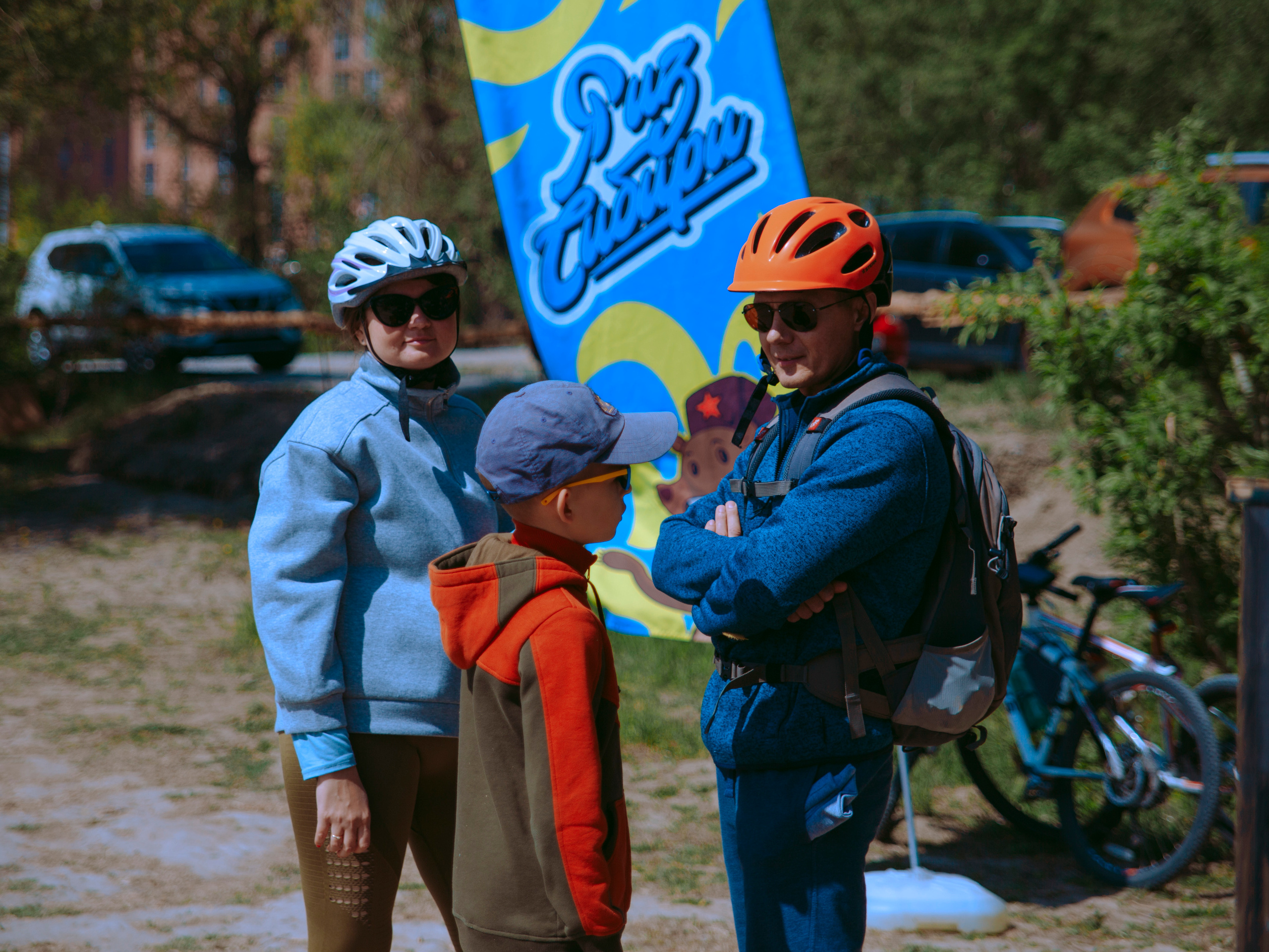 Семья в велосипедных шлемах в солнечный день.