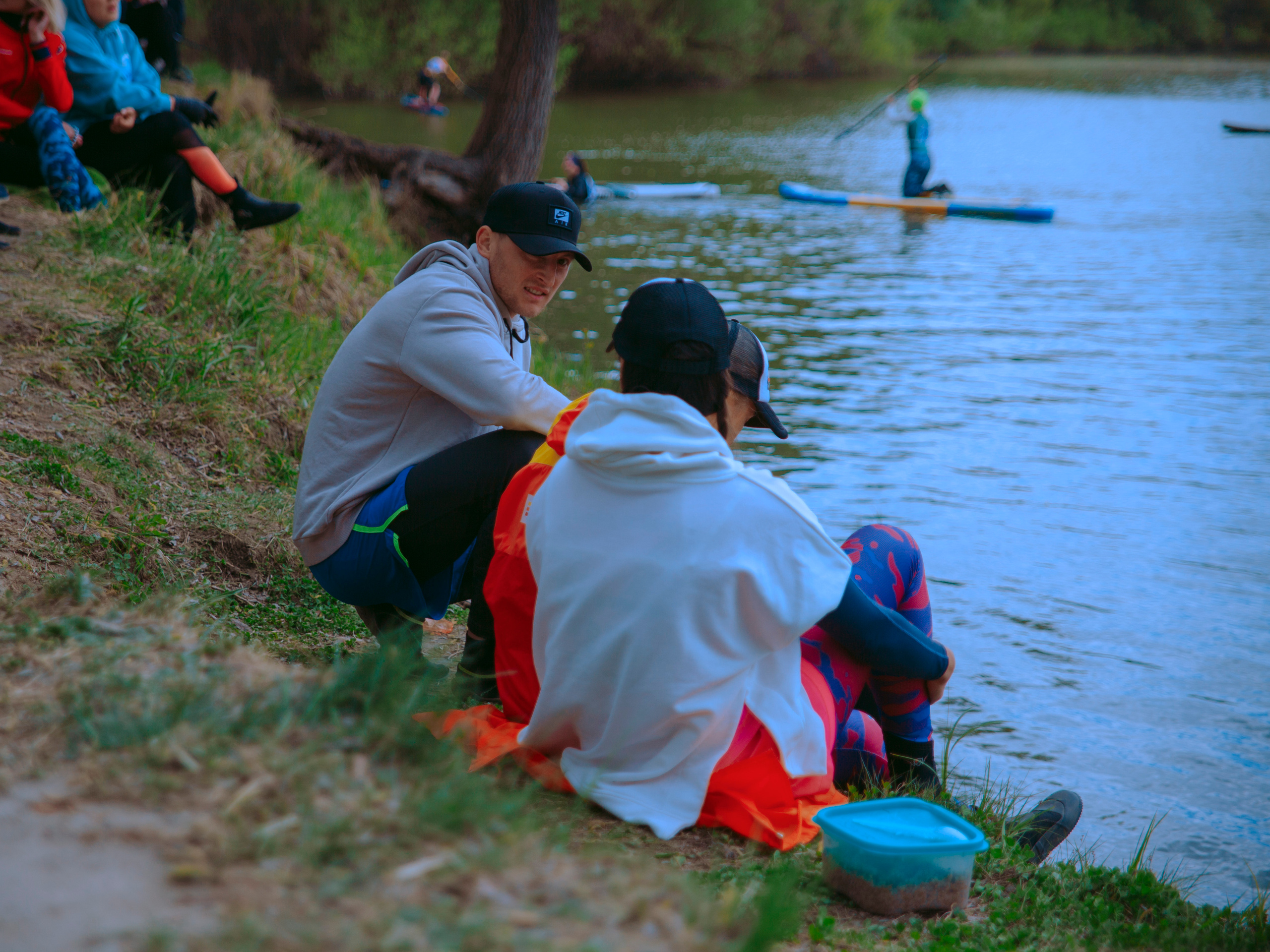 Люди у воды на фоне сапов.