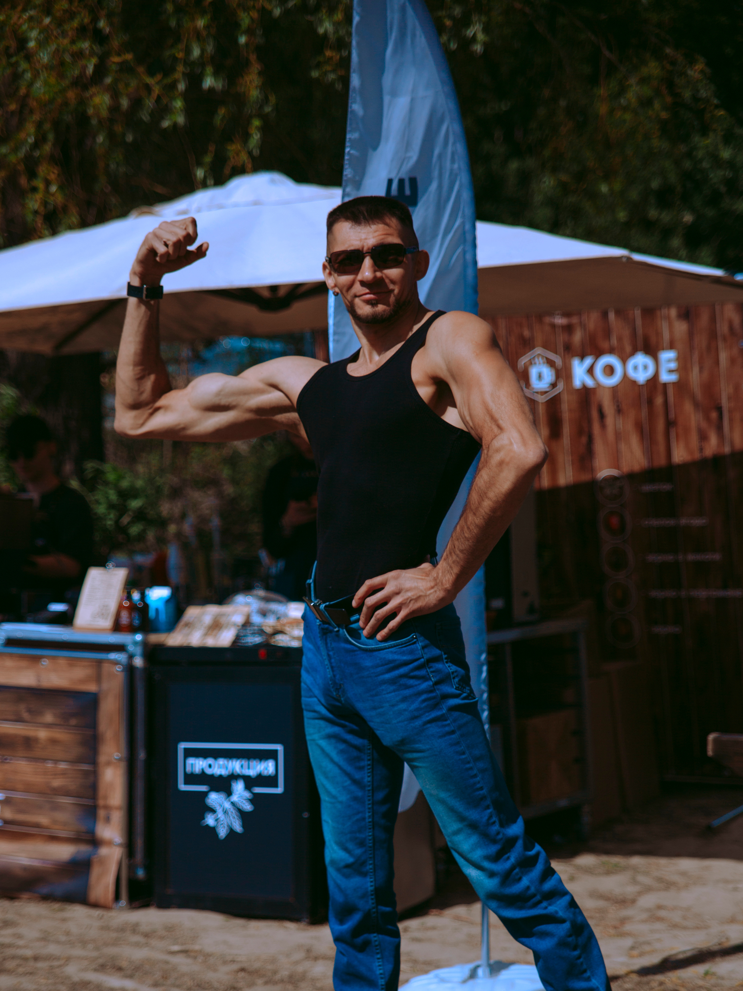 Мужчина бодибилдер хвастается бицепсом.