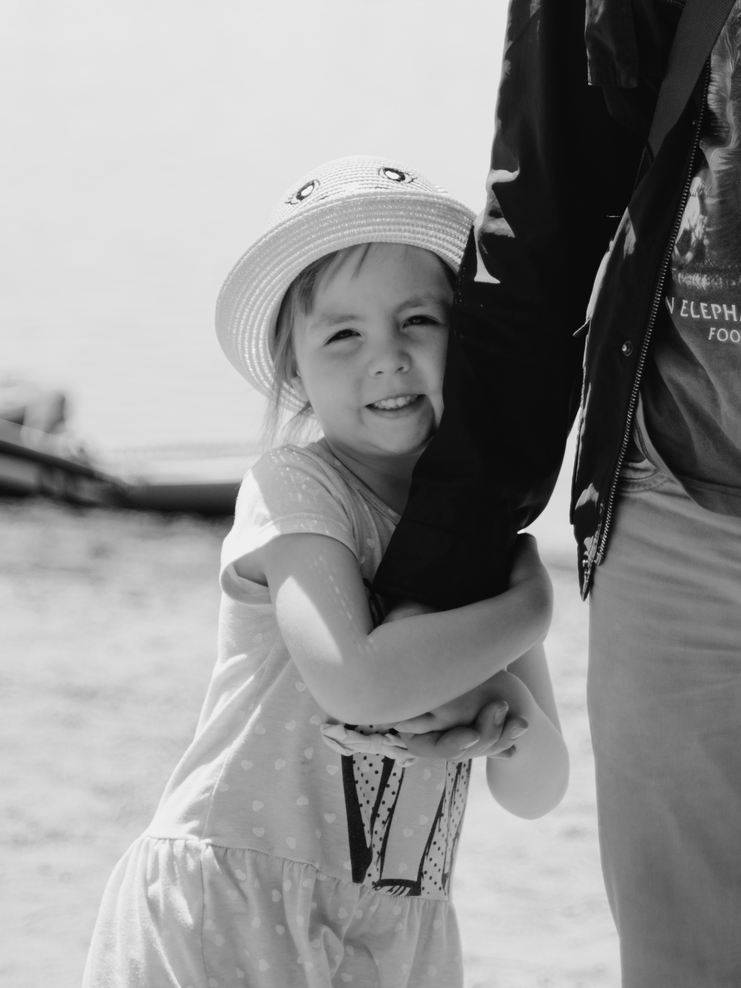 Ребенок обнимает руку отца.