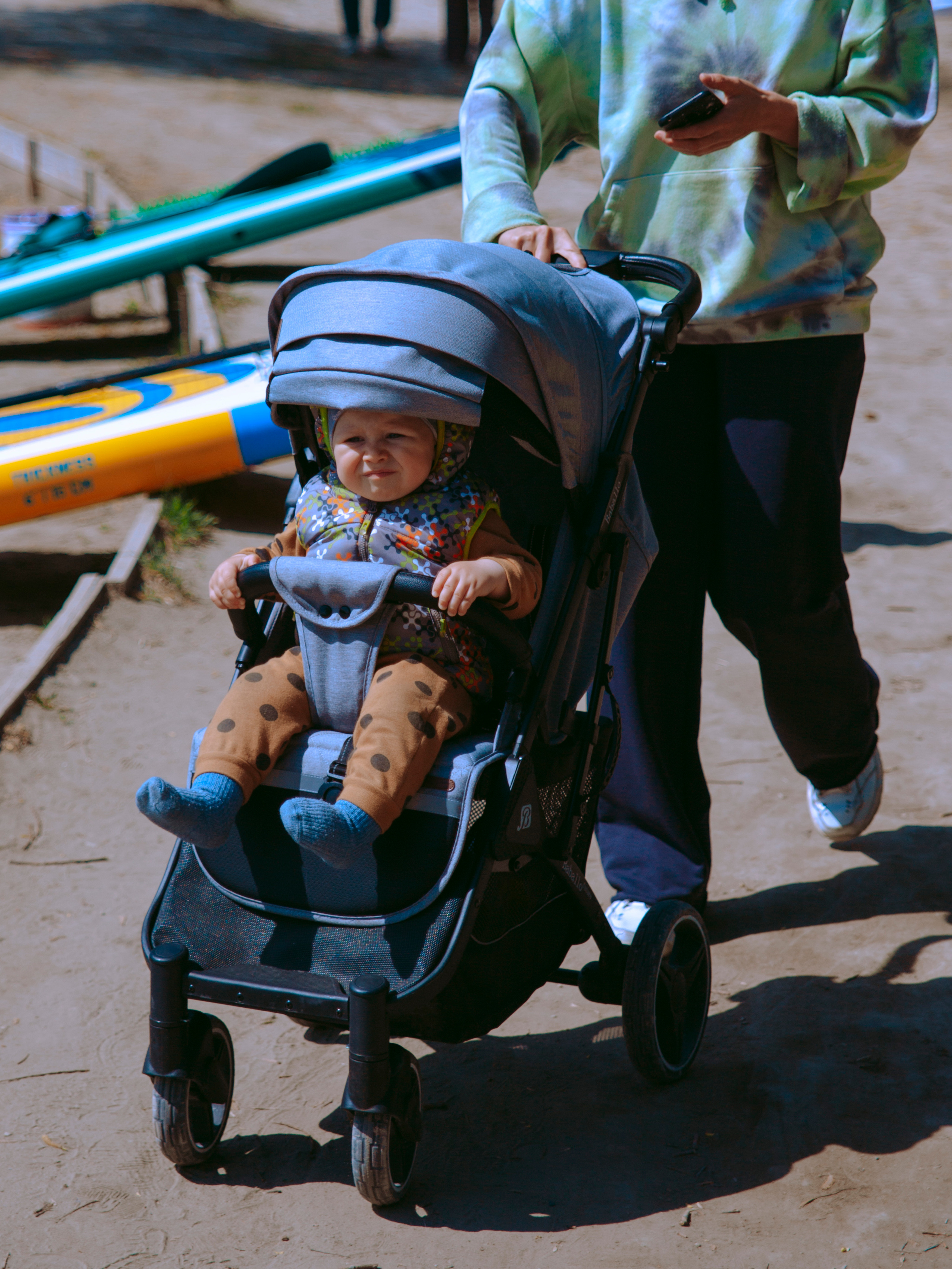 Ребенок в коляске в парке.