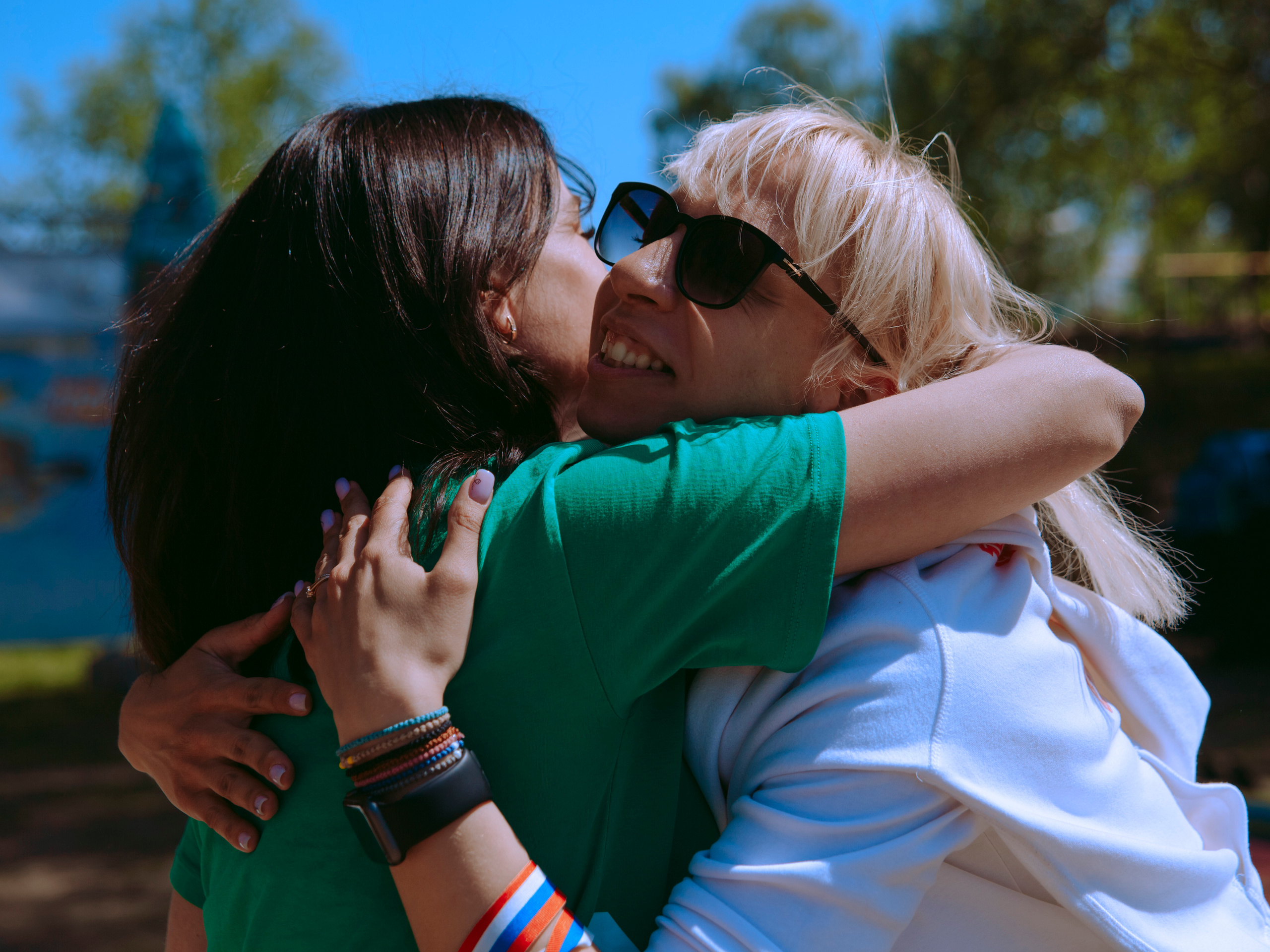 Две женщины радуются встрече и обнимаются.