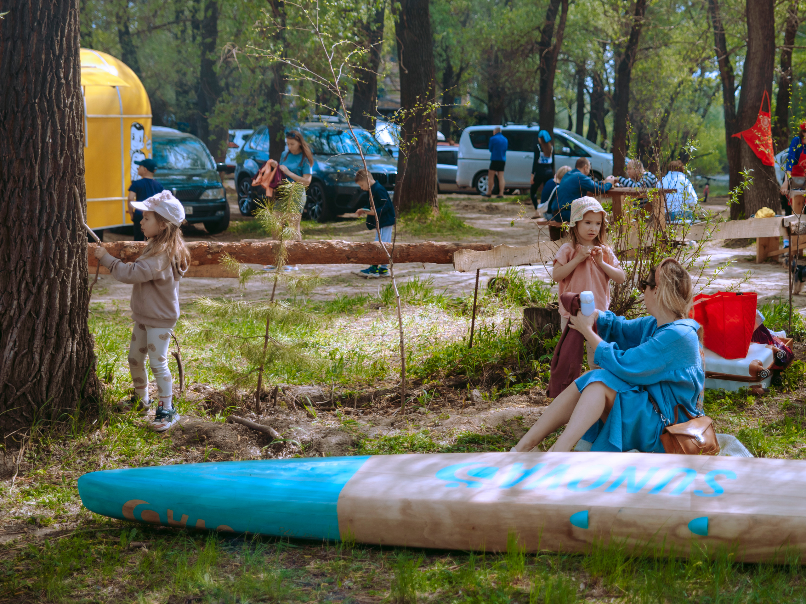Девушка с дочками отдыхает в парке.