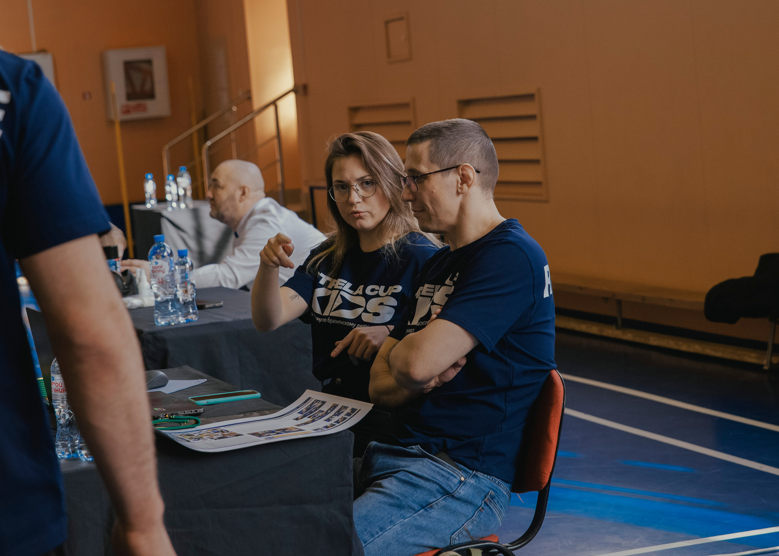 Судьи смотрят в камеру на детском турнире по джиу-джитсу.